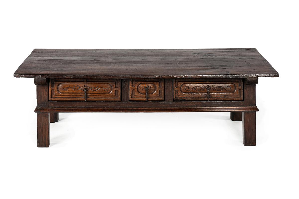 This exceptional Spanish coffee table is entirely crafted from solid chestnut wood. The piece shows a warm deep-brown color and a rich patina, the result of centuries of use and careful preservation.
The tabletop is particularly remarkable: it is
