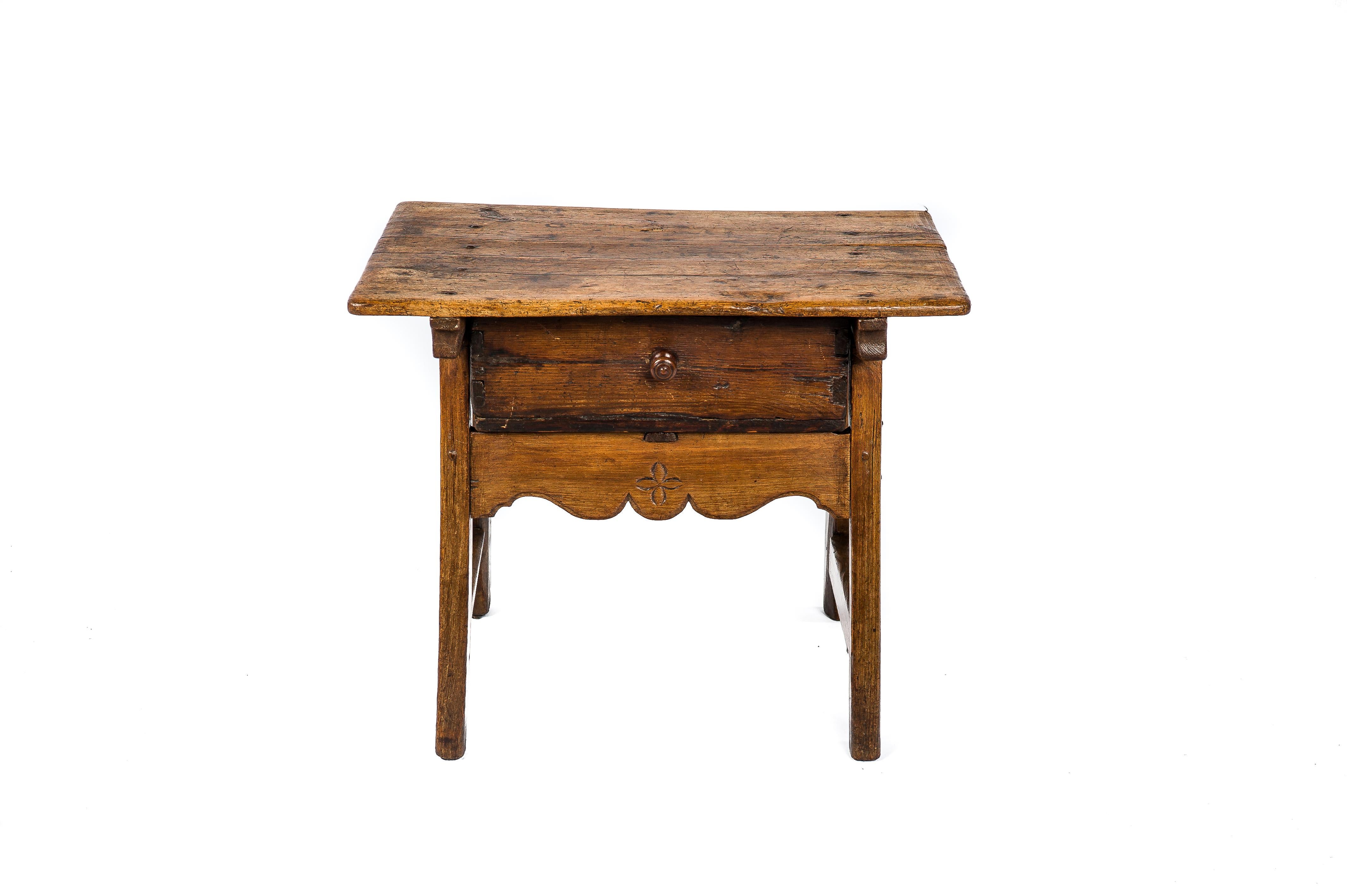 A beautiful antique side table that was made in provincial Spain circa 1750. The solid chestnut three planks rectangular top was jointed to the base by forged steel nails. The table features a single pine drawer with wooden with a curved apron