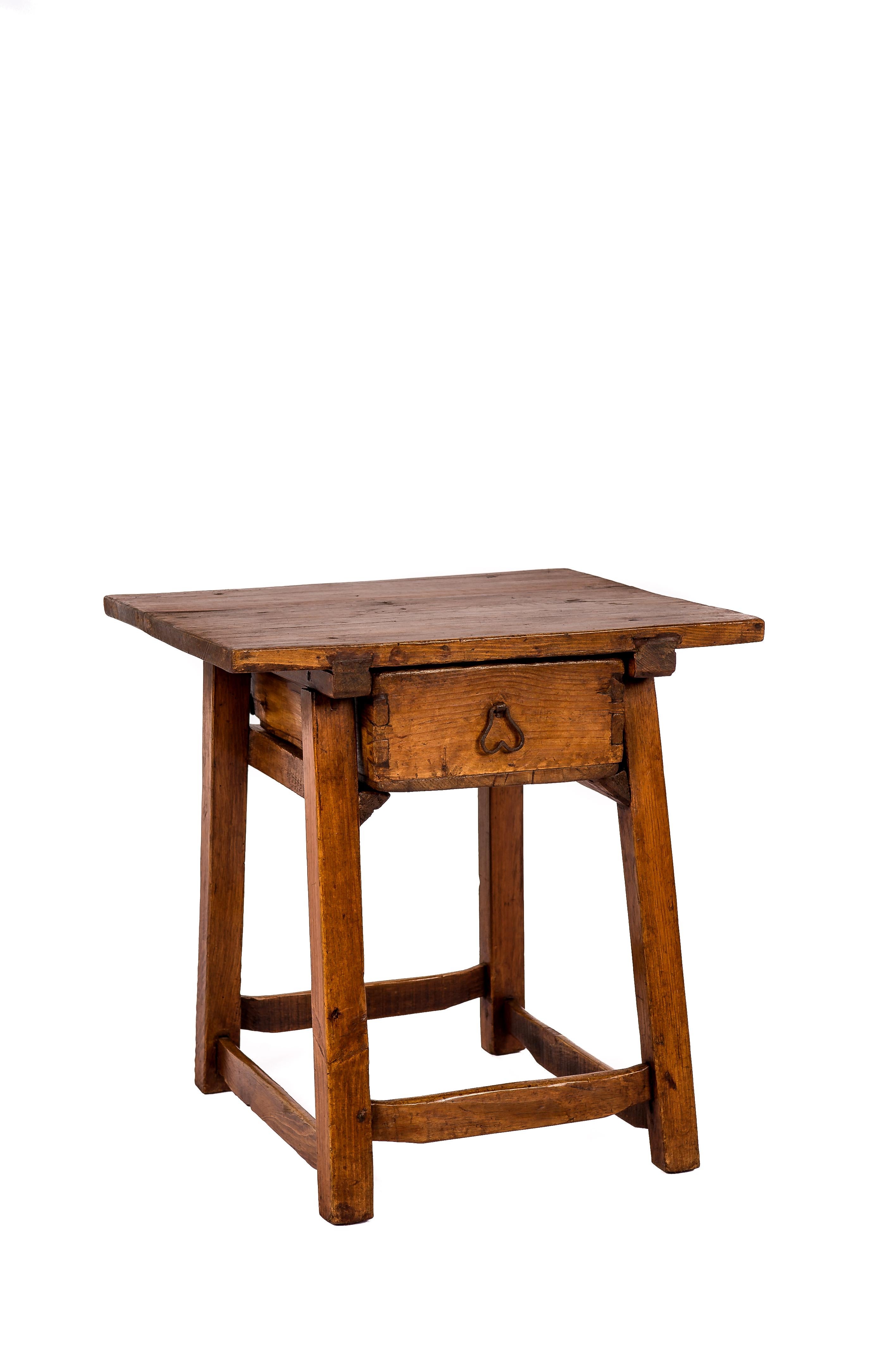 A fantastic antique side table or occasional table that was made in rural Spain circa 1750. The rectangular top was made from two boards of solid elm wood and was jointed to the base by classic dovetail stretchers. The table features a drawer with a