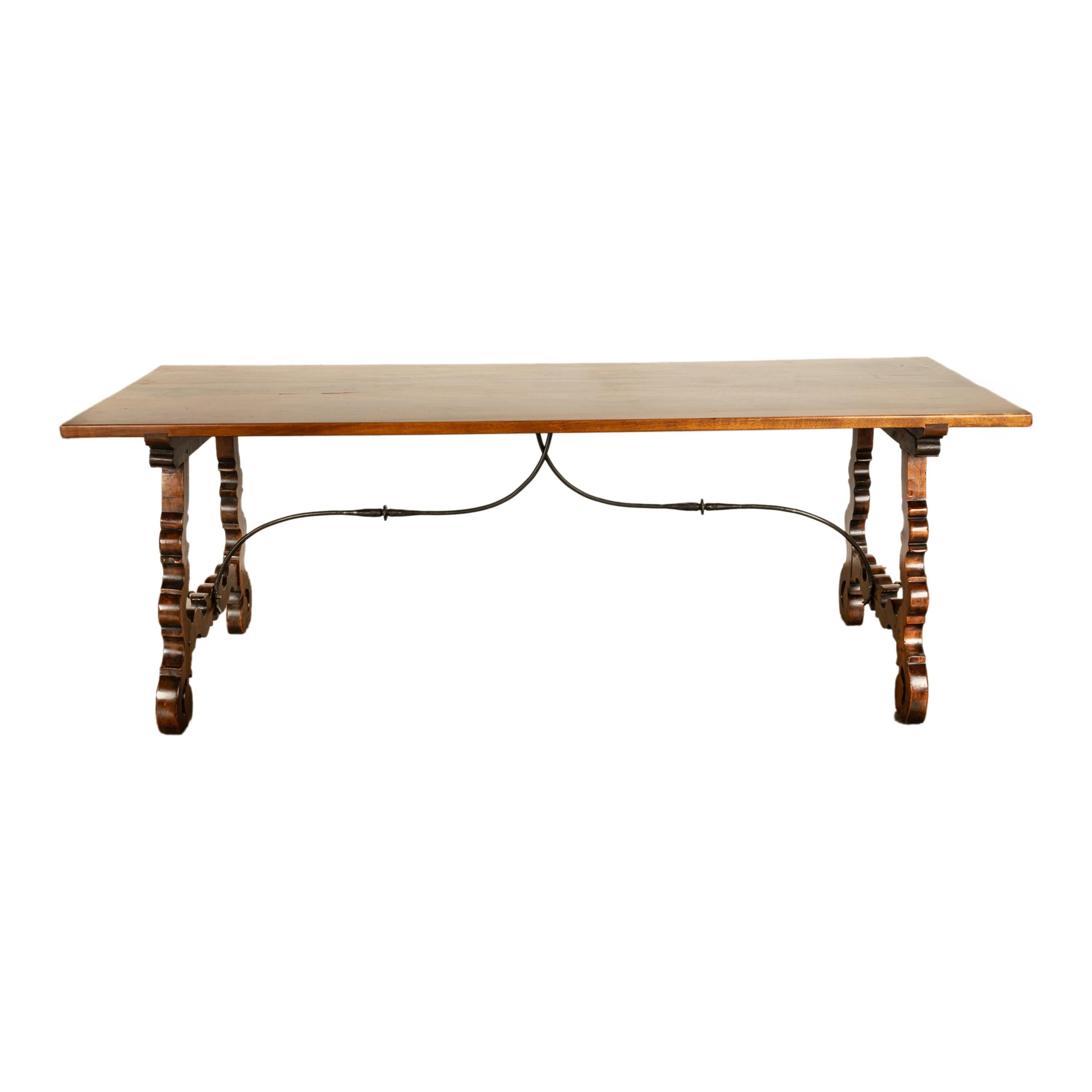 Buena mesa de refectorio barroca española del siglo XVIII, de nogal tallado y hierro forjado, hacia 1780.
La mesa, con tablero rectangular y elevada sobre extremos tallados en forma de lira, está unida con un bastidor de hierro forjado en forma de