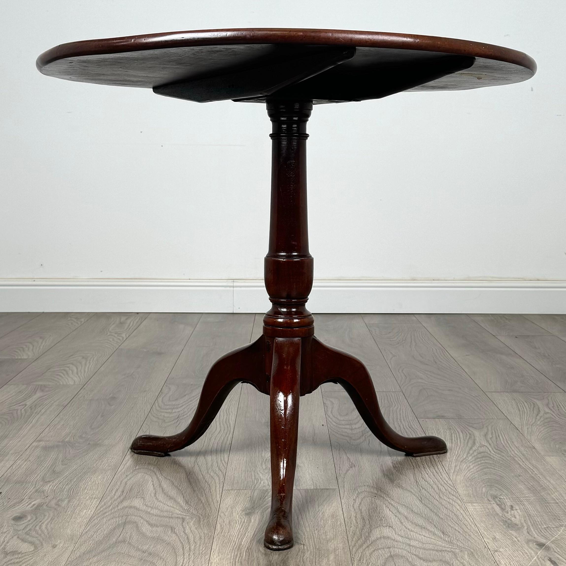 Exquise table à plateau basculant du XVIIIe siècle, fabriquée d'une main de maître à partir d'une seule pièce d'acajou. Cette pièce élégante est soutenue par une base tripode finement détaillée, mettant en valeur l'artisanat exceptionnel de
