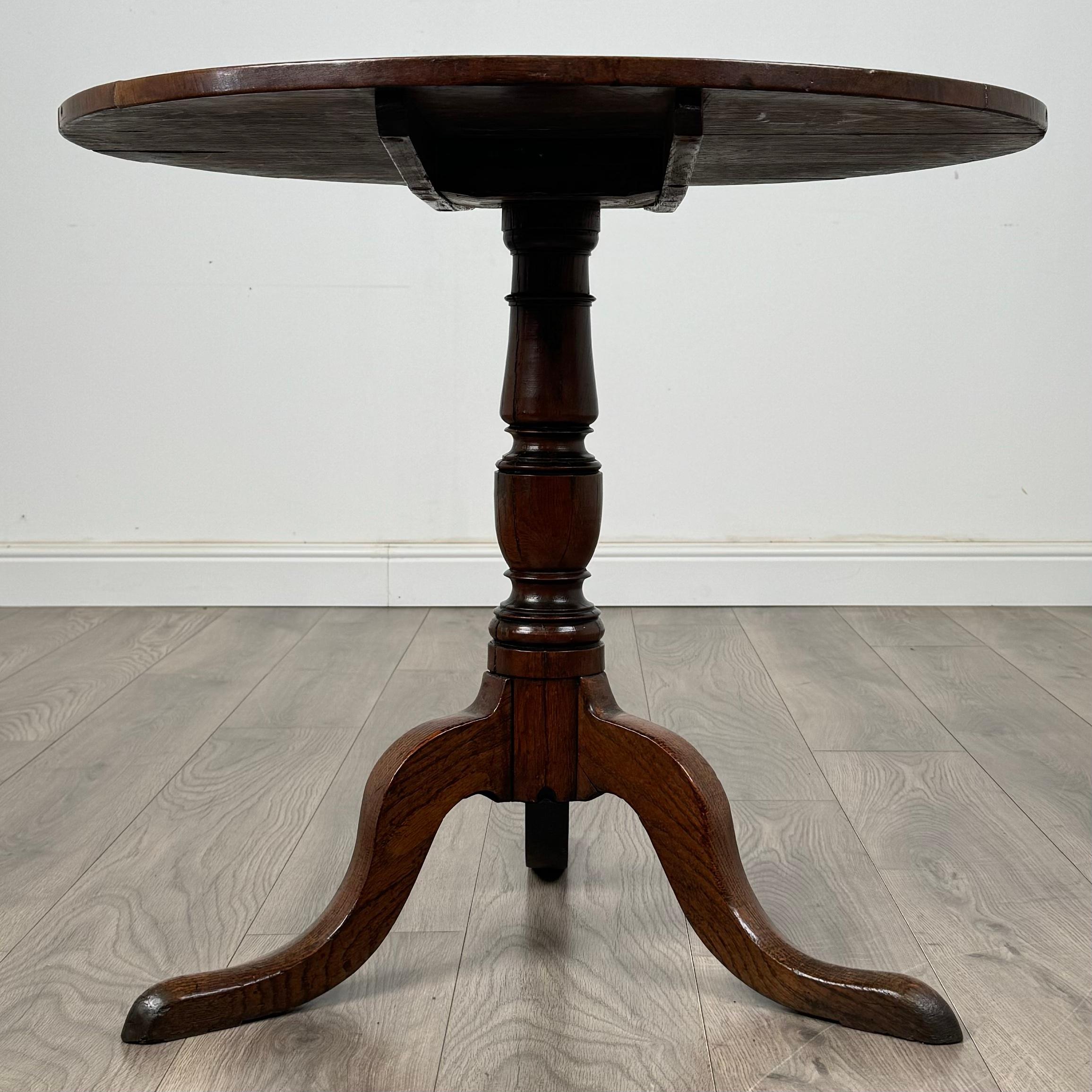 Une élégante table à plateau basculant du XVIIIe siècle en chêne, dotée d'une belle base tripode qui met en valeur son design classique. Le plateau de la table présente un grain étonnant et une riche patine, reflétant la haute qualité de