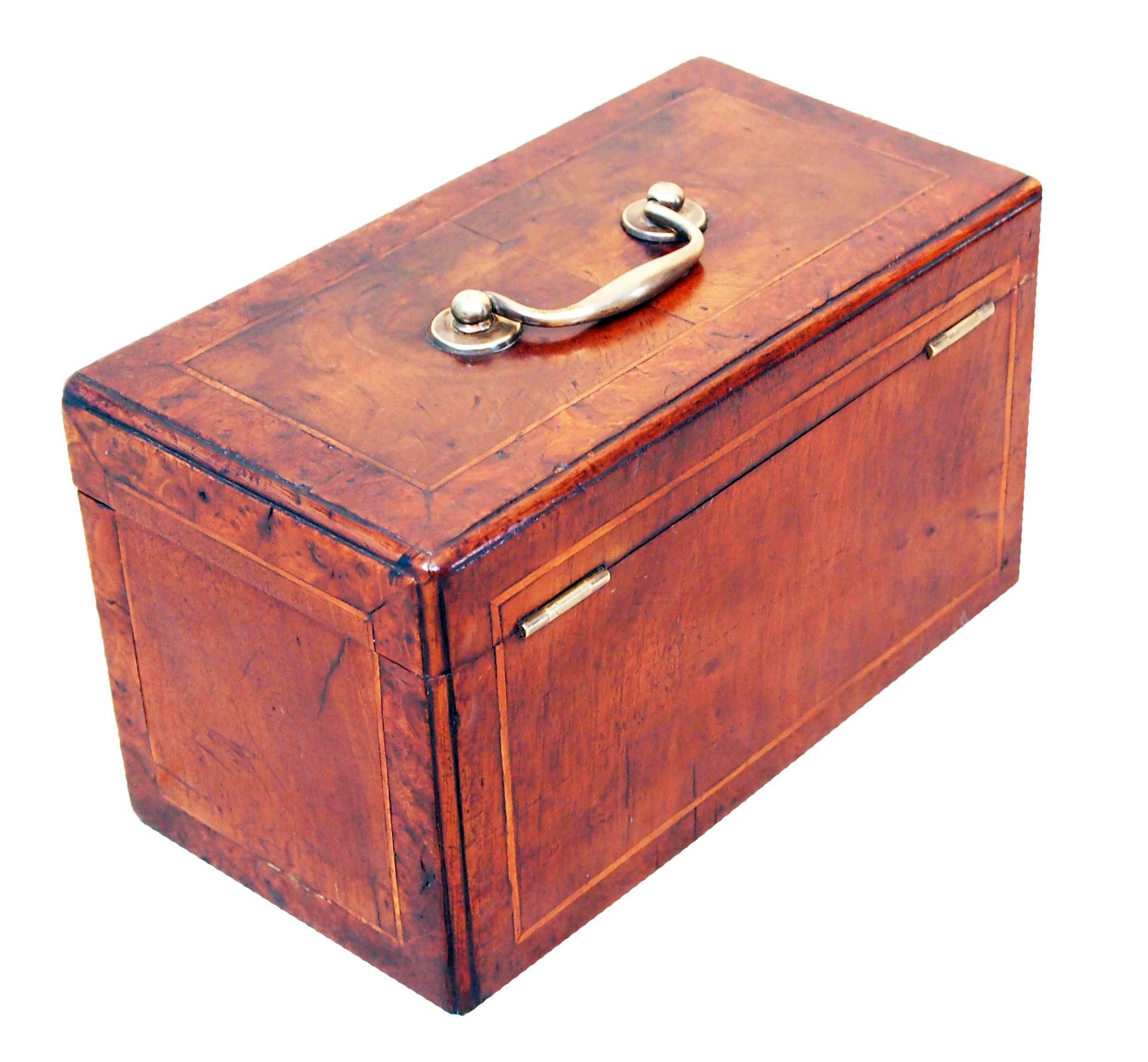 A very attractive mid-18th century walnut tea caddy having re-entrant
molded corners, crossbanded and strung decoration retaining
original brass handle and key escutcheon.

(Tea caddies are of course one of the most collectible antique