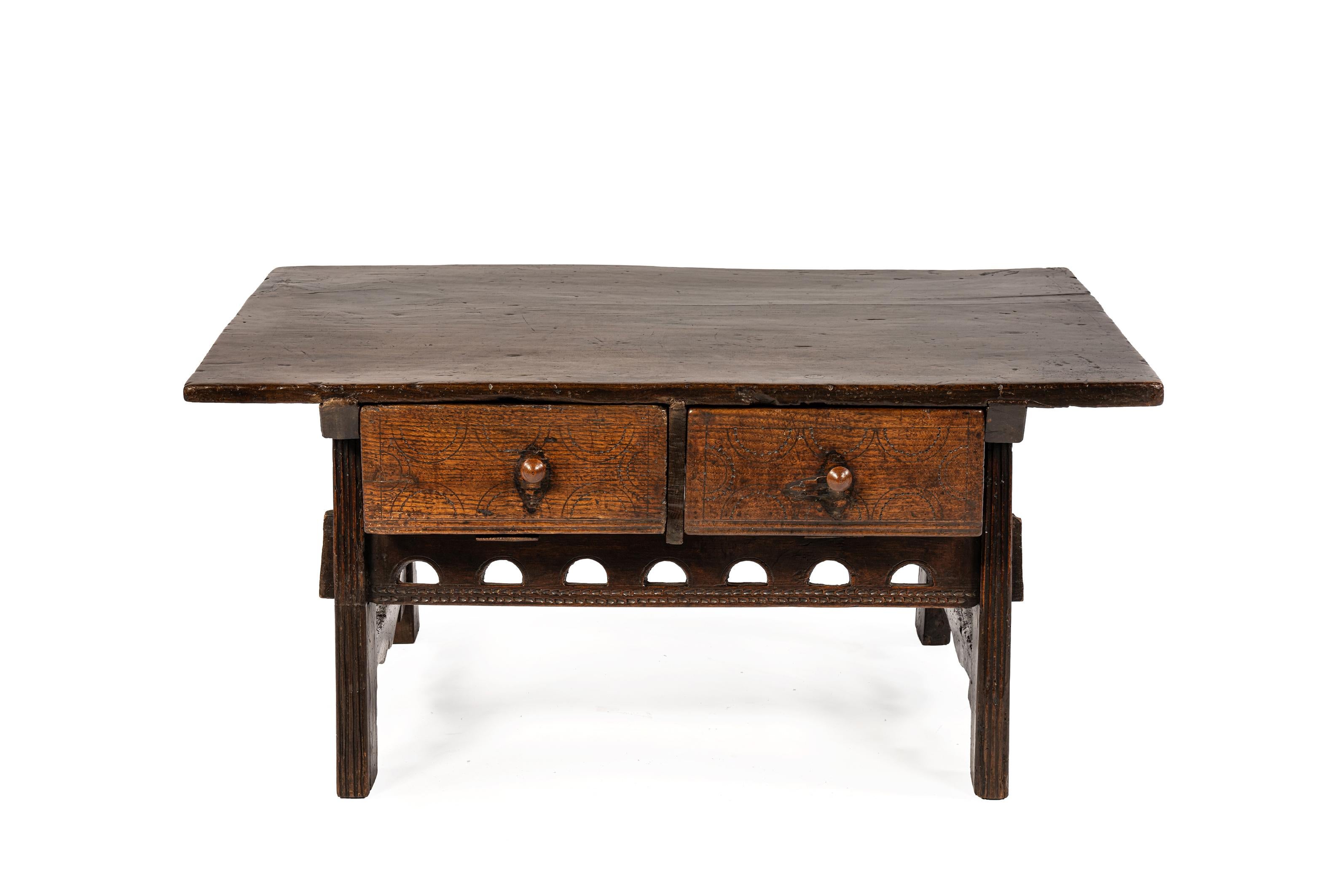 Se trata de una antigua mesa de centro española, fabricada a finales del siglo XVIII o principios del XIX (hacia 1780-1820) y originaria de las regiones del interior del norte de España. La pieza pertenece al estilo tradicional de mobiliario rural