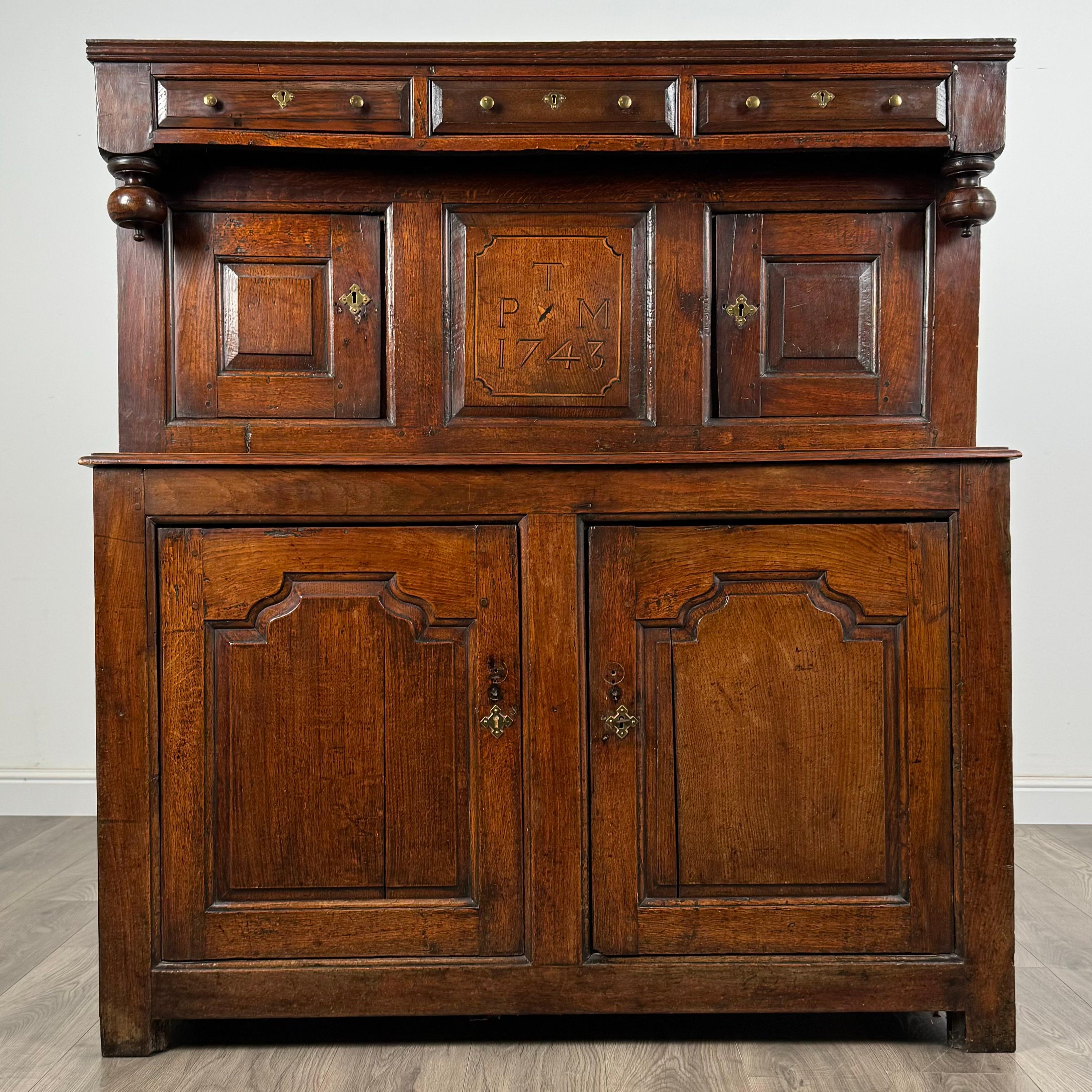 An exquisite 18th-century Welsh Deuddarn cupboard in solid oak, featuring a beautifully inlaid centre panel adorned with the date 