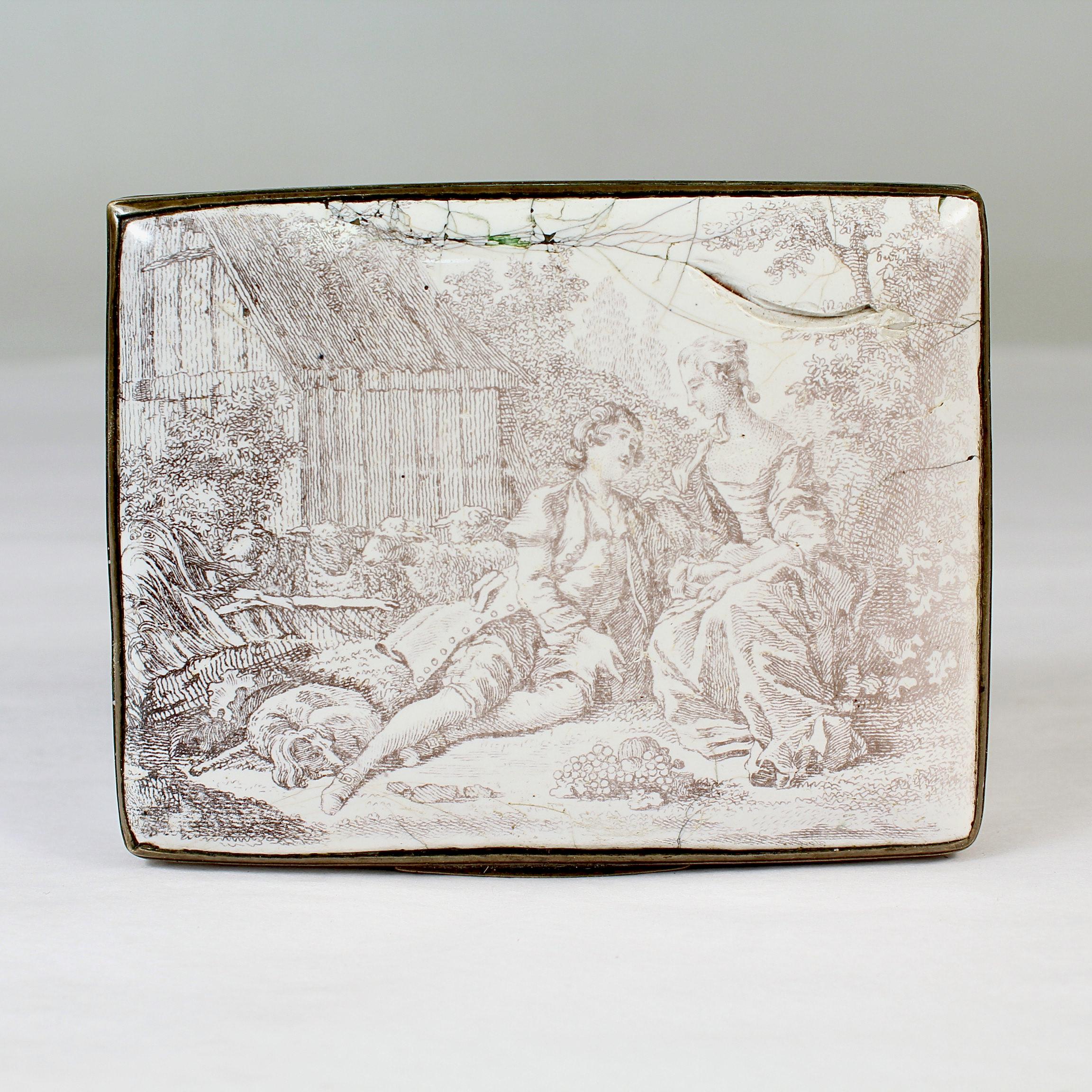 A fine antique 18th Century Battersea / Bilston bonbonniere or snuff box. 

With a white ground and grisaille transfer decoration throughout. 
 
The top depicts an idyllic scene of a man lounging next to a woman in a garden accompanied by sheep