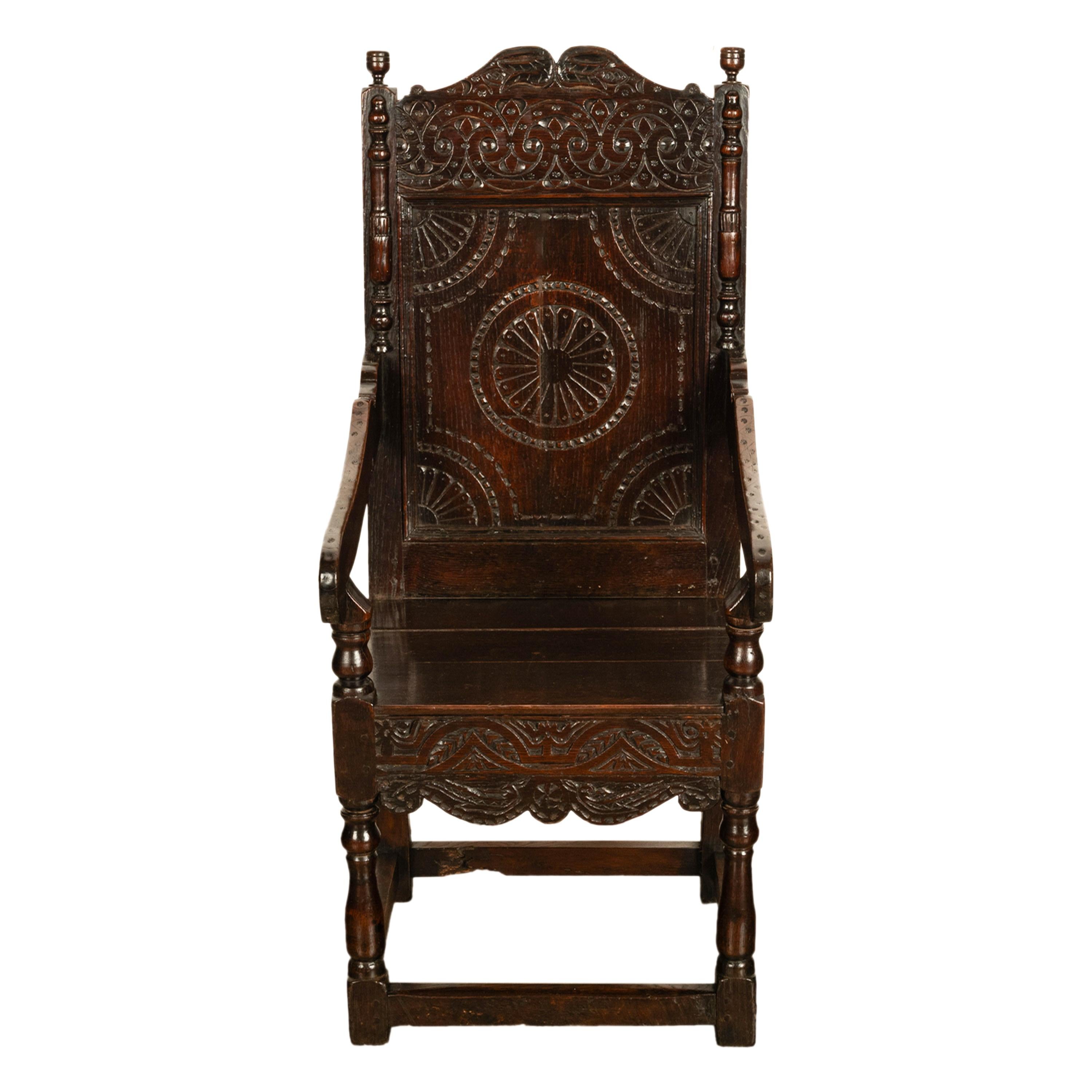 Chaise en chêne sculpté de George I, Yorkshire, vers 1720.
La chaise est dotée d'un dossier sculpté de motifs entrelacés et d'une paire de fleurons tournés de chaque côté. Le dossier de la chaise est orné d'appliques tournées et de motifs