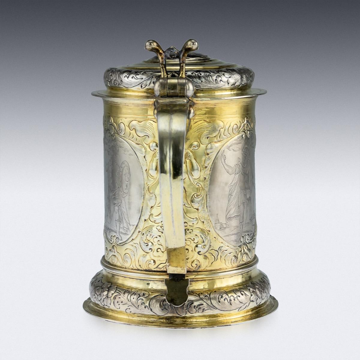 Antique mid-18th century Imperial Russian solid silver-gilt and niello impressive lidded tankard, parcel gilt, of traditional tapering form on a spreading foot, the sides chased with gilt putto masks and trailing foliage and scrolls on textured