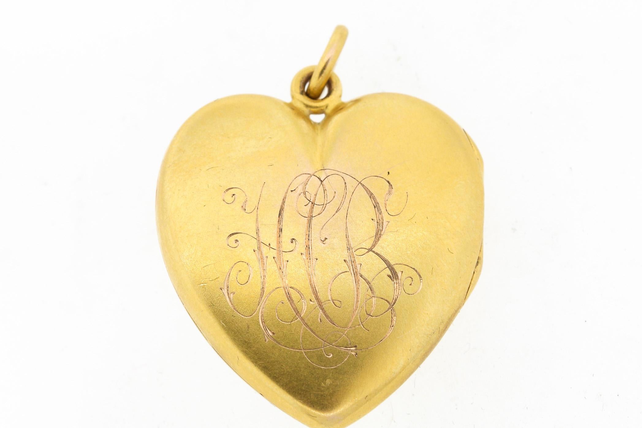 Lovely antique slim heart shaped locket set with a cushion ruby surrounded by rosecut diamonds, circa 1900. The heart has its beautiful original patina, and is marked 14k inside the locket. It has its original crystal inside and even one photo. The