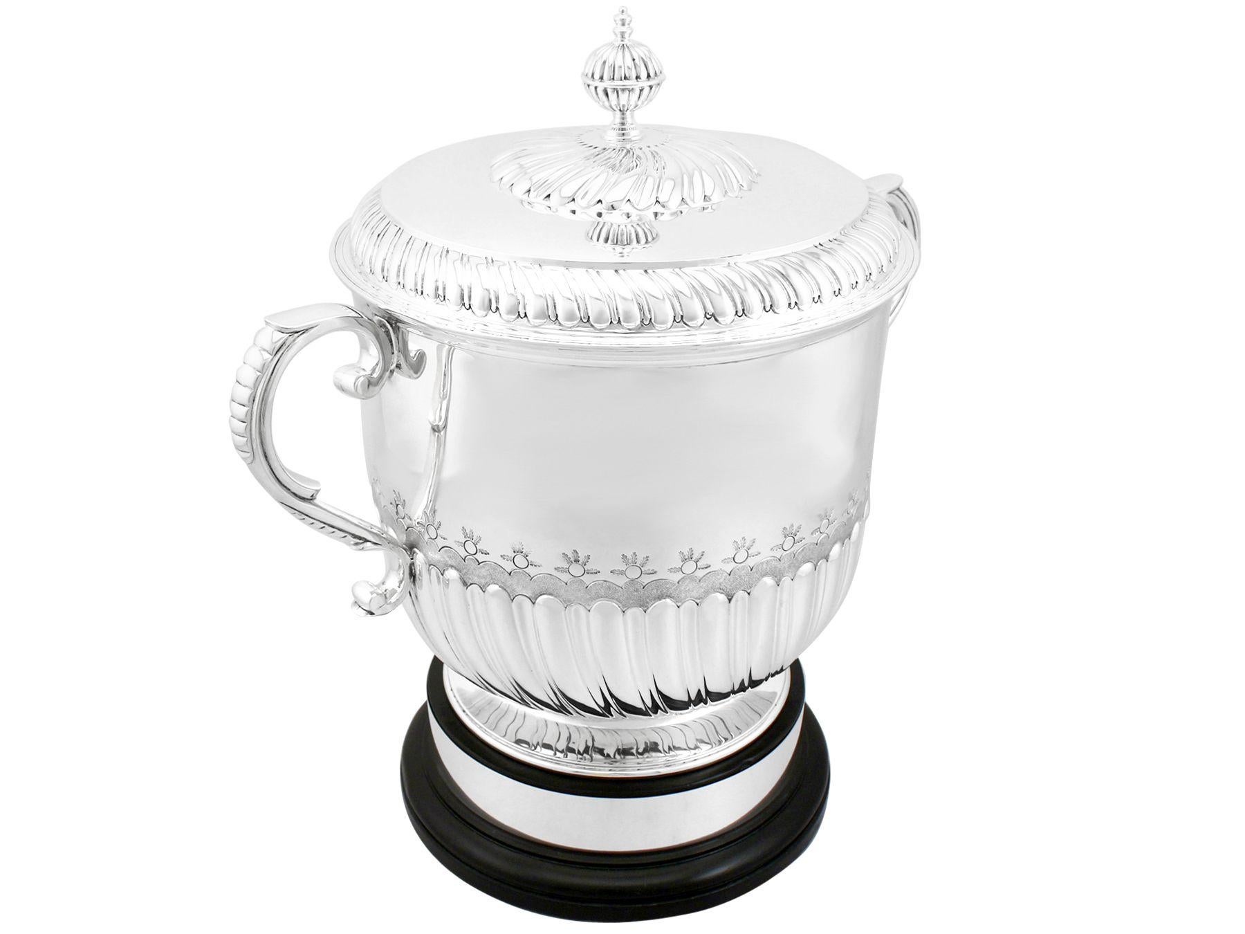 A magnificent, fine and impressive large antique Edwardian English sterling silver cup and cover; an addition to our silver presentation collection.

This magnificent Edwardian sterling silver champagne or presentation cup has a plain circular