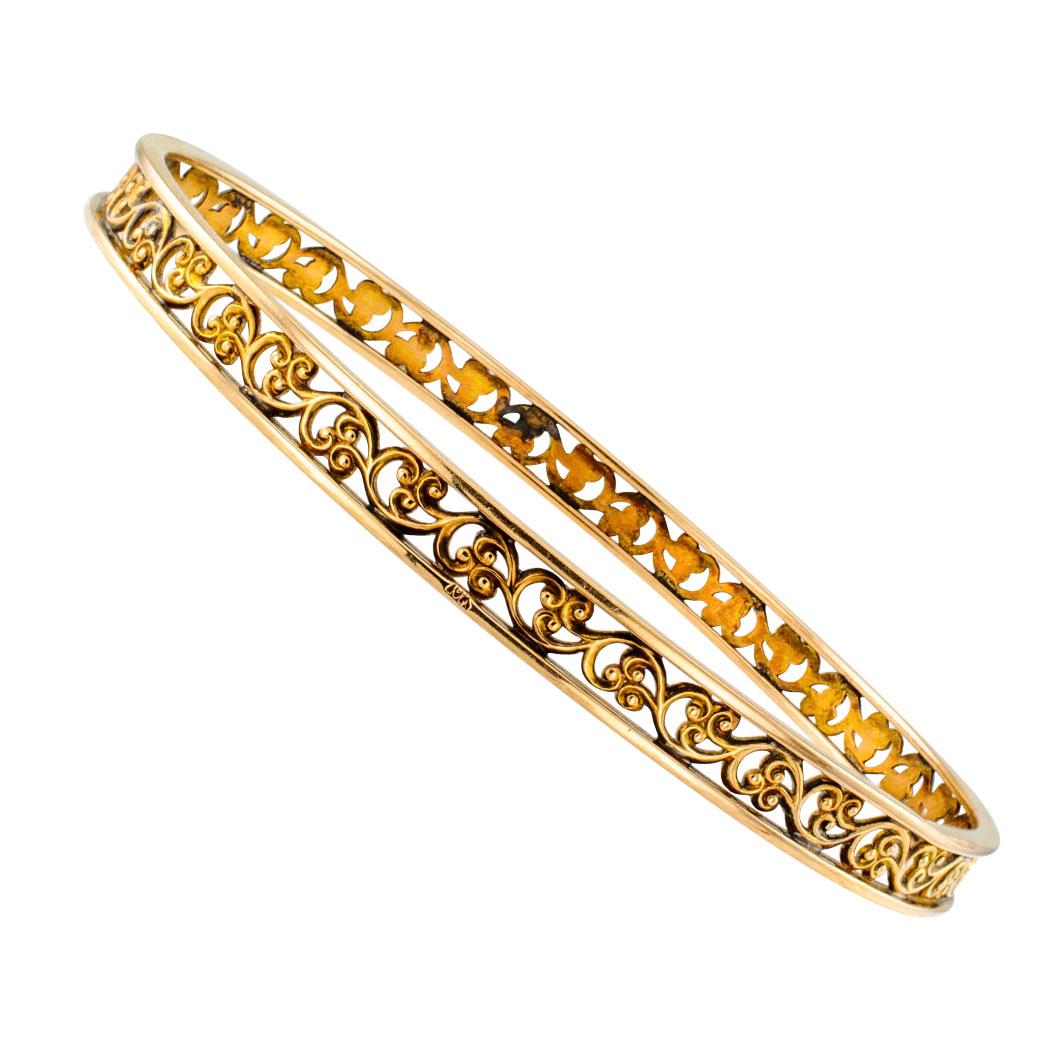 Antique 1900s gold slip on filigree bangle. Crafted in 10-karat yellow gold, the design features continuous open work in scrolling motifs within complimentary solid borders. Excellent condition consistent with age and wear. Looks very good for being
