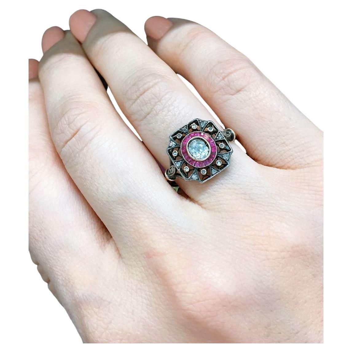 Antique ring in open work style centered with 1 old mine cut diamond estimate weight 0.40 carats flanked with baguet cut natural rubies and smaller diamonds ring is in 14k gold topped with silver dates back to 1900.c (note 1 small ruby missing)