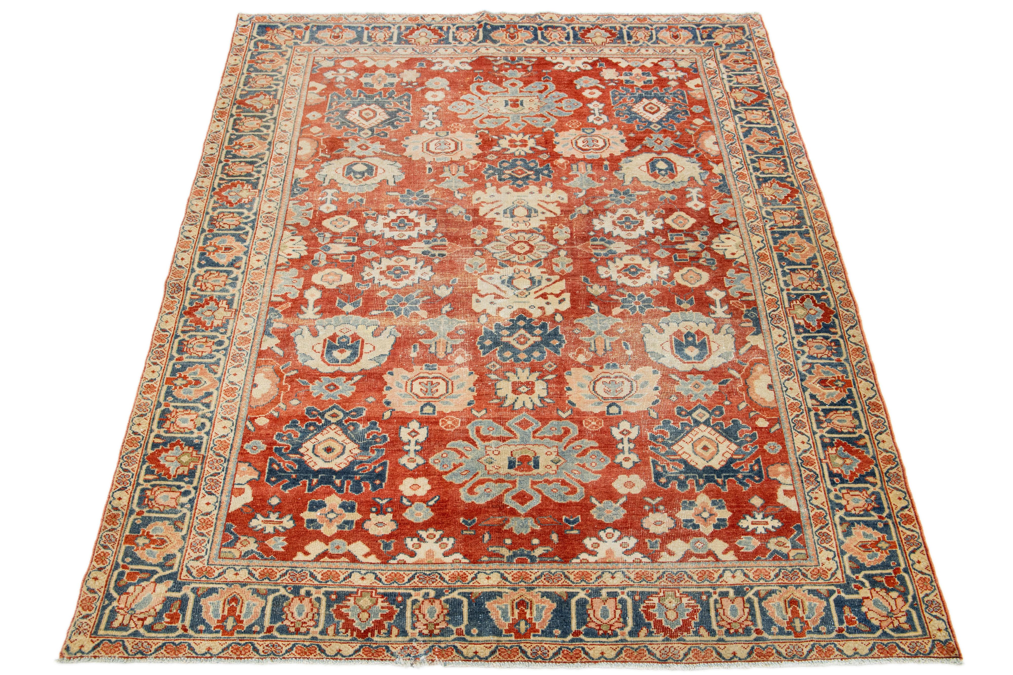 Beautiful Antique Mahal hand-knotted wool rug with a red-rust color field. This Persian rug has blue, peach, and beige hues throughout the allover floral motif.

This rug measures 5'11