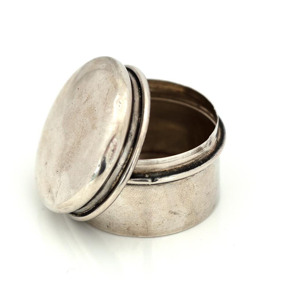 Un pot antique en argent sterling d'une grande sobriété, conçu à l'origine pour un usage domestique ou de voyage, et aujourd'hui réimaginé comme une élégante boîte à souvenirs. Parfait pour placer près de votre lit une bague qui vous est chère -