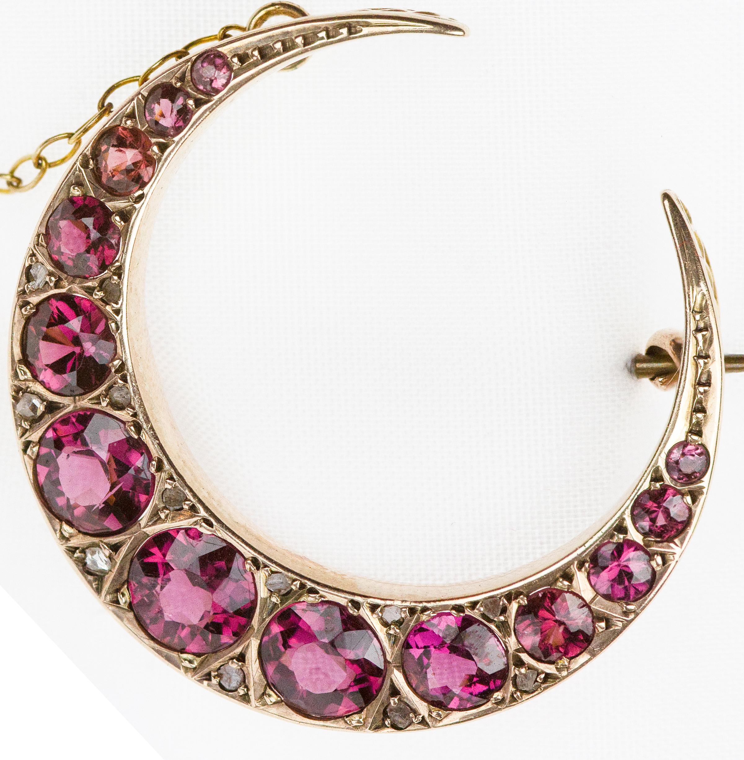Gorgeous, this crescent moon brooch-made with 9 ct gold hallmarked UK Chester 1909, garnet and diamond is a fantastic accessory to any piece of clothing and can make a divine gift to someone special. 
On the brooch is several garnet circular gems,