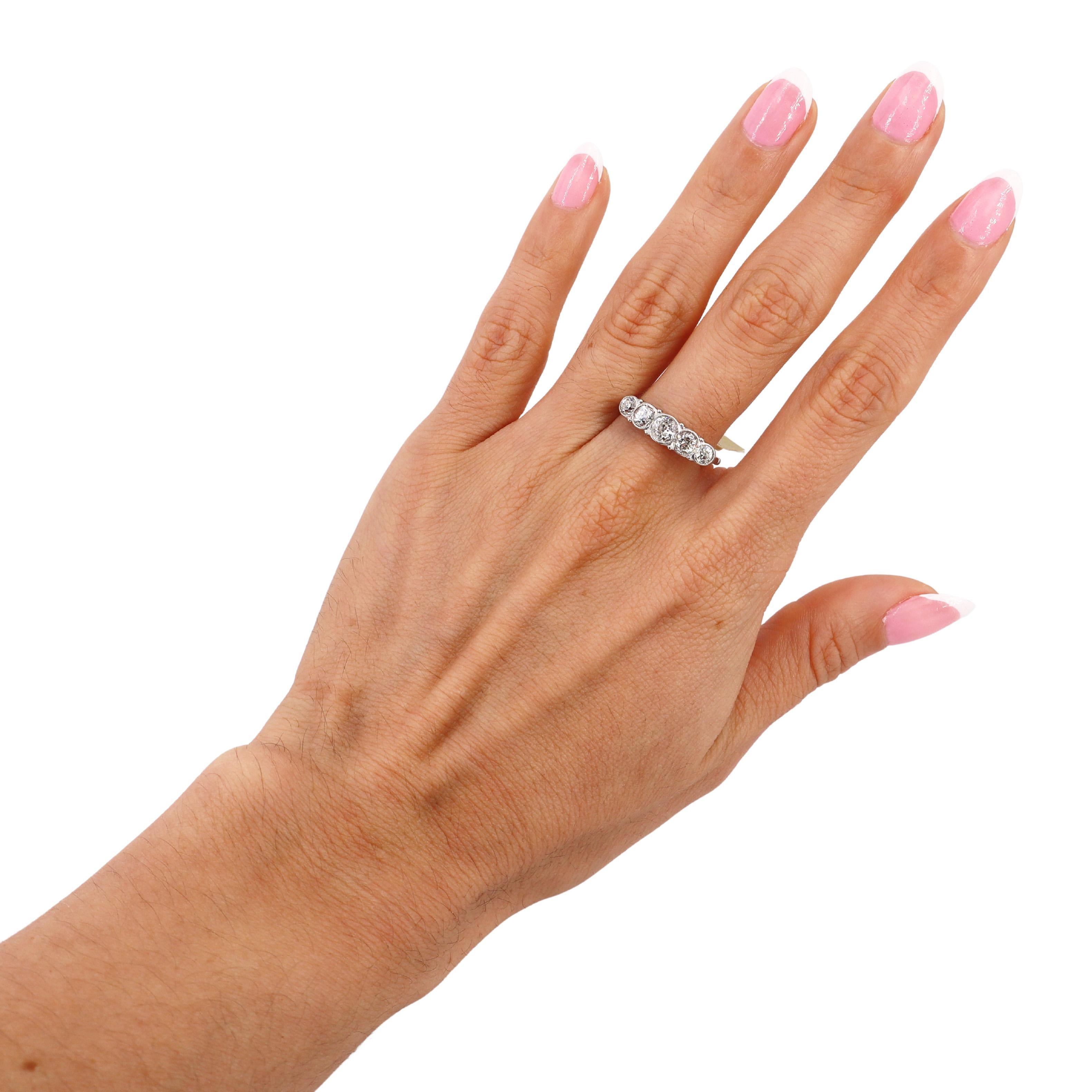 Cette bague ancienne à cinq pierres, fabriquée dans les années 1910, est un exemple exquis de l'élégance du début du XXe siècle. Fabriqué en or blanc 18 carats, il présente des bords milgrain, qui ajoutent une texture raffinée et complexe au