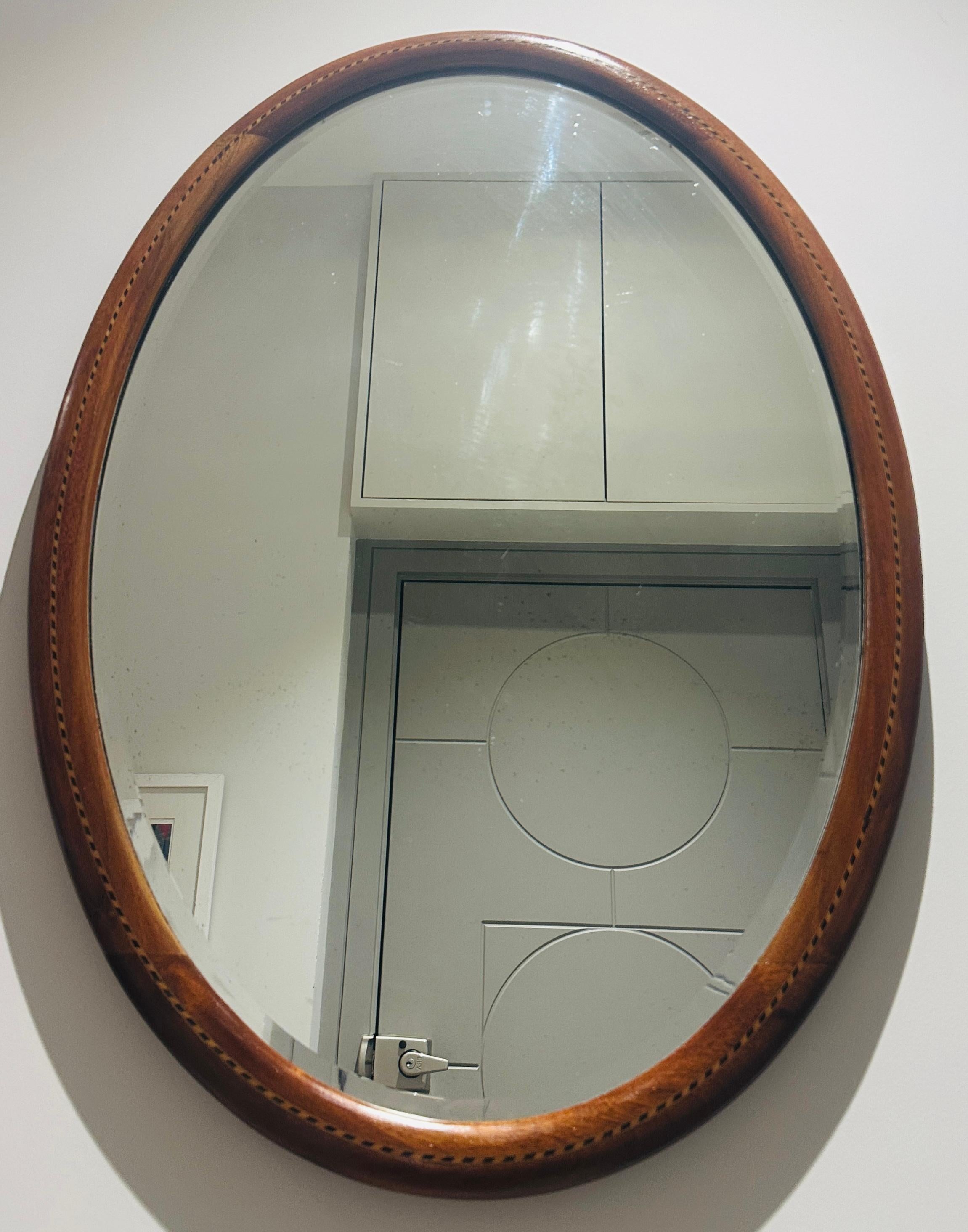 Un élégant miroir ancien à cadre ovale en acajou de la période Elegardienne, avec une marqueterie de rubans.  Datant d'environ 1910.  Fin de l'époque édouardienne.

Le cadre a été entièrement restauré par un restaurateur professionnel.  Le miroir en
