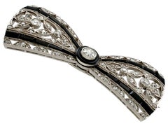 Antique 1910s 1.35 Carat Diamond and Black Onyx Platinum Bow Brooch
