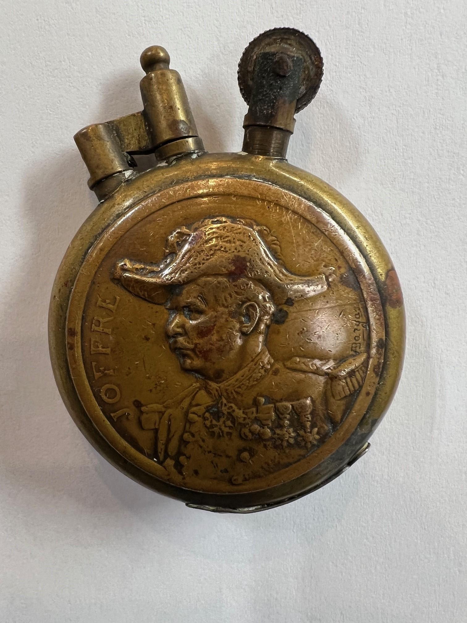 Very unique Trench art, WW1 era brass petrol lighter, on one side is the portrait of Marshal 
Joseph Joffre. Marshal Joffre was the Commander in Chief of the French forces on the Western Front from 1914 to 1916. He is best known for his victory