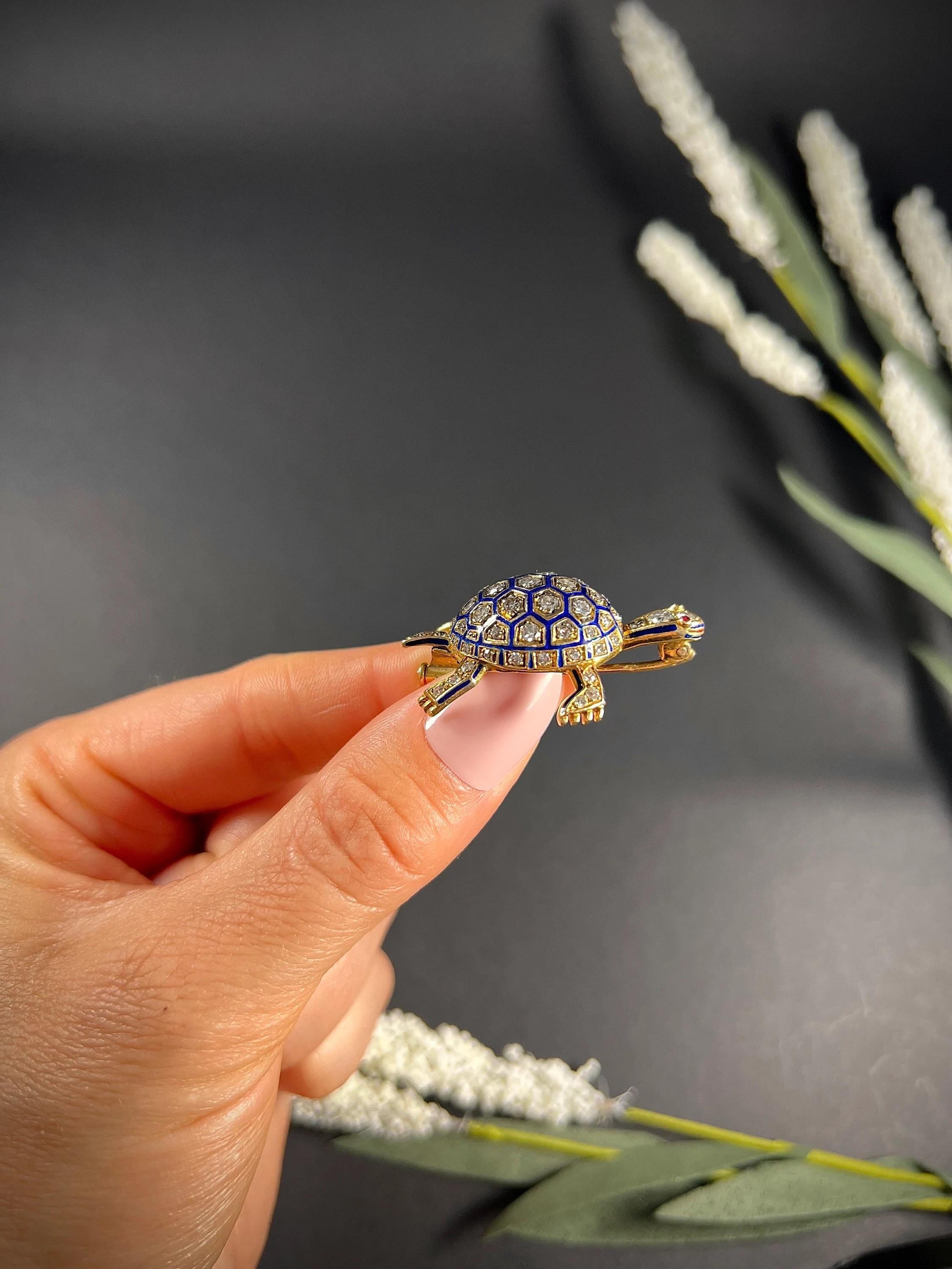 Antike Schildkröten-Brosche

18ct Gold Getestet 

CIRCA 1920er Jahre

Wunderschöne, antike Schildkrötenbrosche. Mit wunderschöner blauer Emaille und herrlichen Diamanten im Altschliff besetzt. Die Details sind so hübsch, von der gemusterten Schale