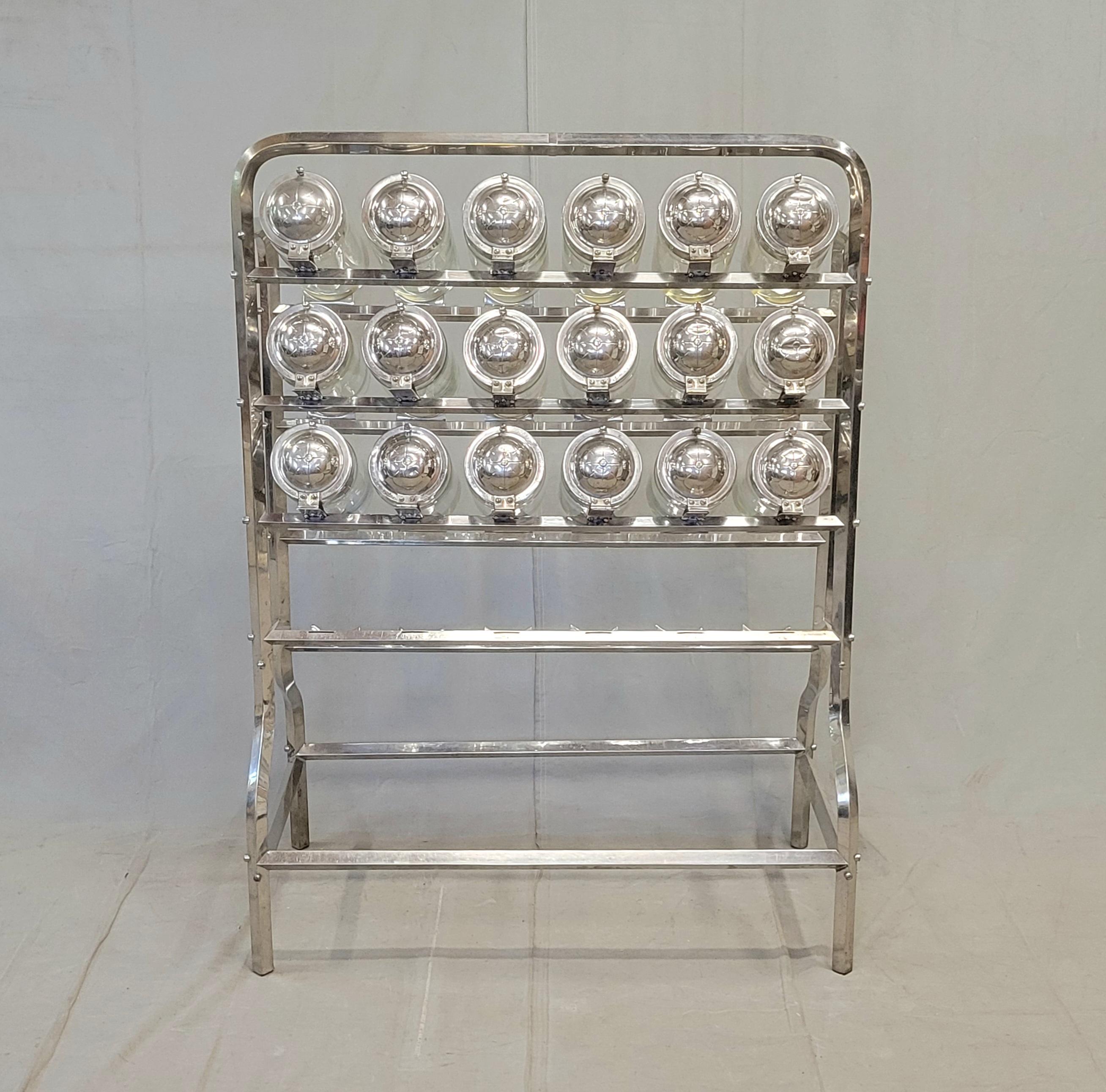 Impresionante y funcional expositor antiguo de dieciocho botes para tienda de caramelos (Caramelera) fabricado por Vendosolo (Vendo Solo) en Argentina en los años veinte o treinta. Dieciocho de los botes están intactos, aunque uno tiene una grieta