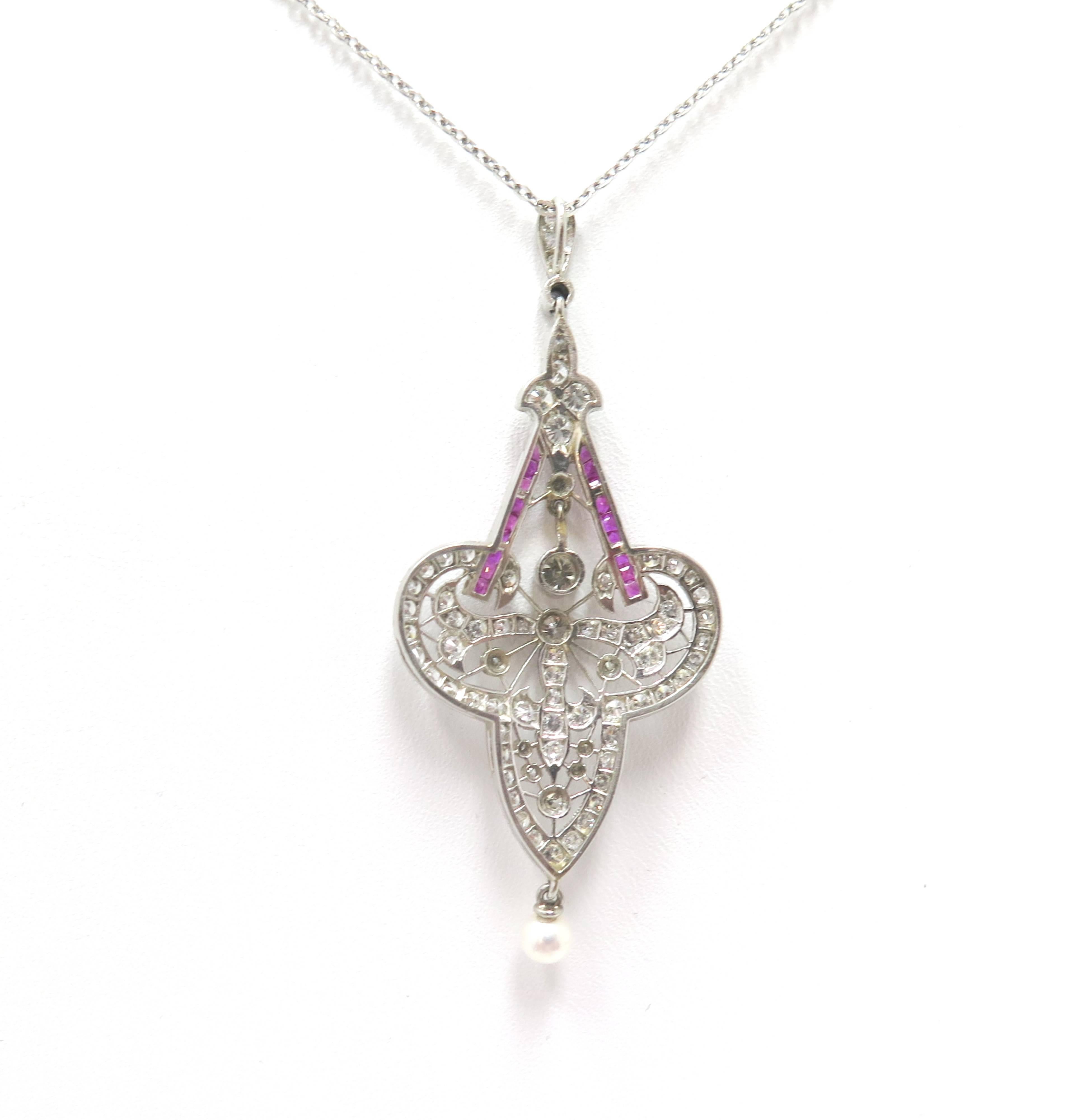 This truly unique and gorgeous antique necklace dates back to the 1920's and displays a curvaceous, classic Art Nouveau motif with sparkling diamonds, luscious rubies, and one dangling cultured pearl. 

A magical one-of-a-kind jewel.

Platinum
Comes