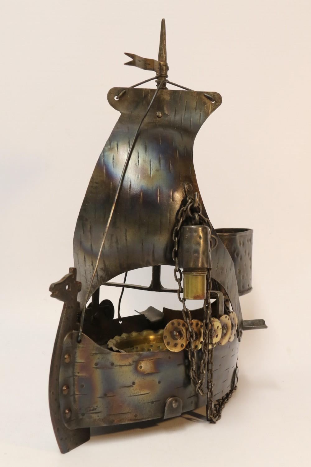 This stylish craftsman's made one off Arts & Crafts piece has been made in the form of a Viking long boat out of wrought steel which has been shaped and rivetted with hammered texturing and a heat blued finish. It comprises of the main vessel which