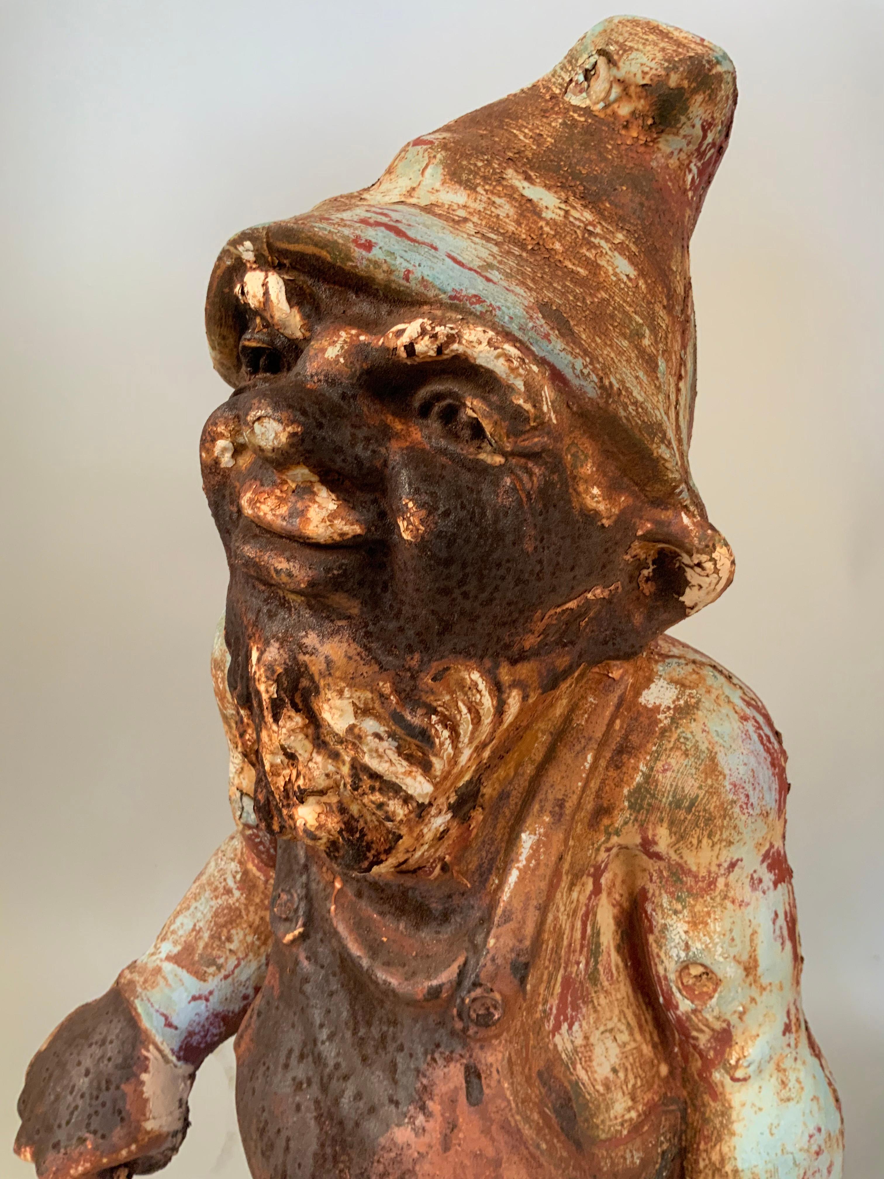 A wonderful antique American 1920s cast iron garden gnome, having a charming form and features, and expressive facial features. Age expected wear with some rusting as pictured.