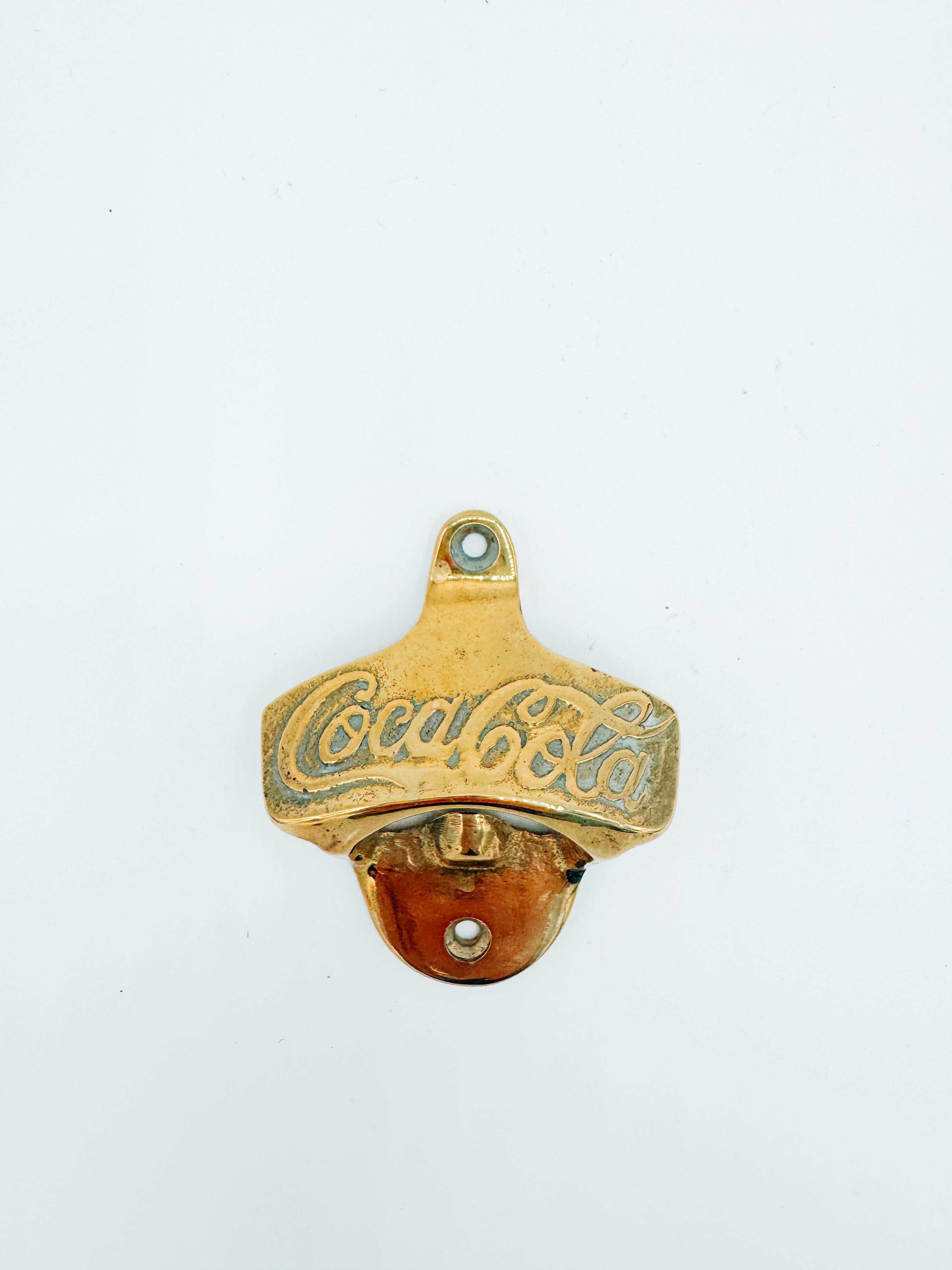 Décapsuleur mural original de Coca-Cola datant des années 1920. Fabriqué en laiton massif avec le logo classique 