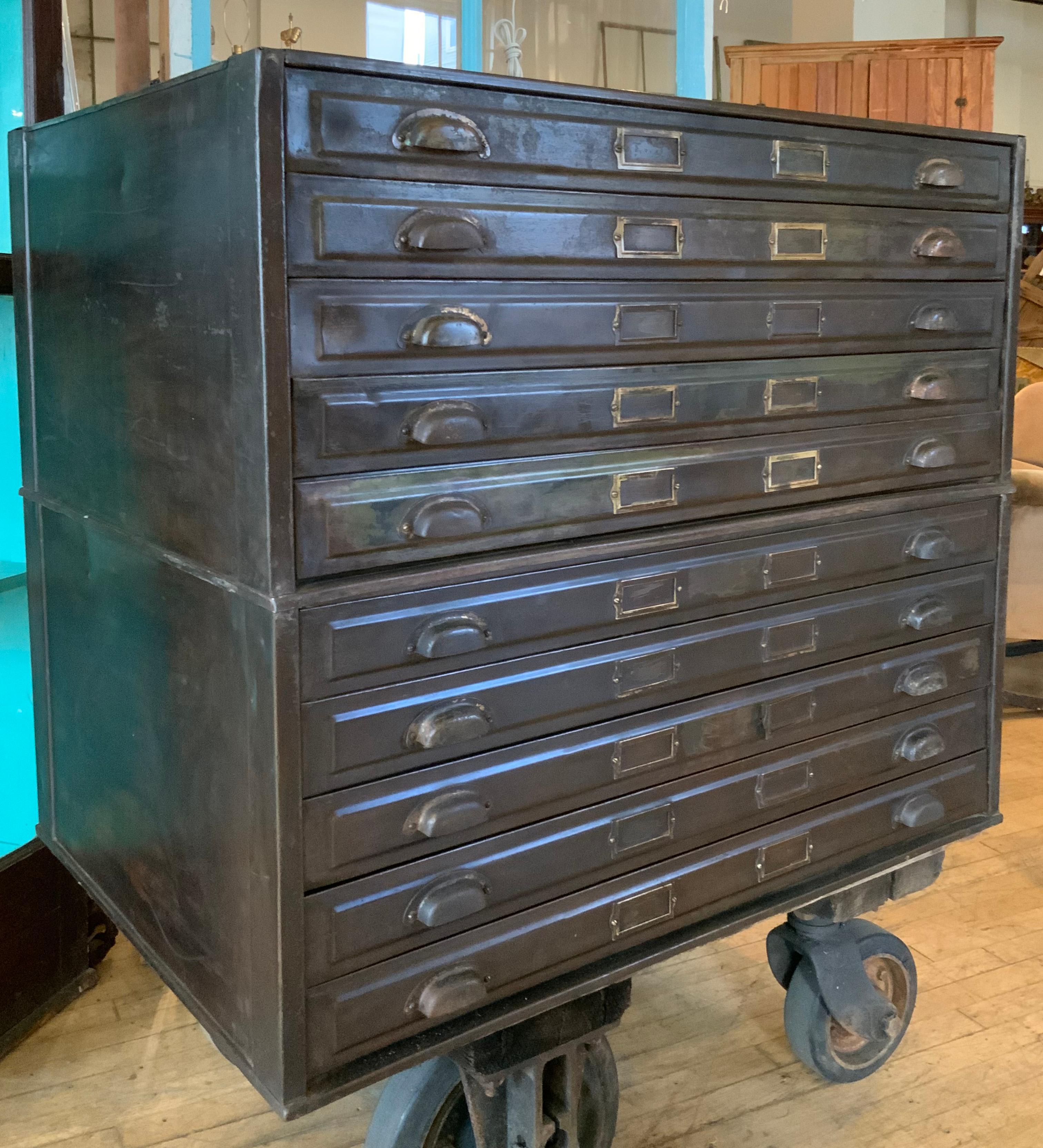 A very handsome double set of antique 1920's steel flat files, in their original dark green/black painted finish. each case has five wide drawers, some divided, some full width. each drawer has its original hinged steel flap for keeping the contents