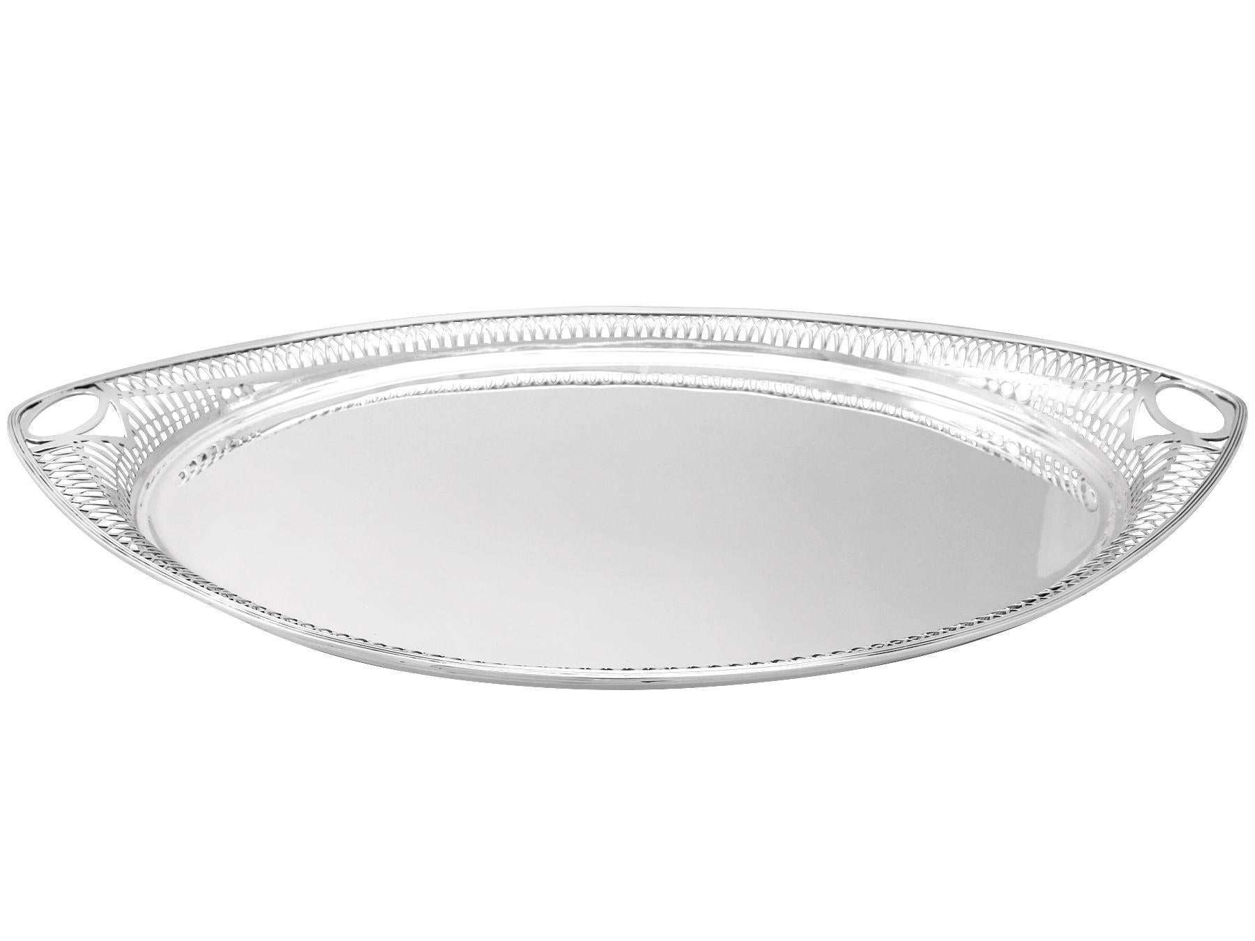 A fine and impressive antique George V English sterling silver galleried tea tray; an addition to our antique silver teaware collection.

This fine antique George V sterling silver tea tray has a rounded navette shaped form.

The surface of the