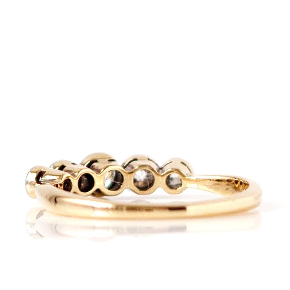 Tauchen Sie ein in die zeitlose Eleganz der 1920er Jahre mit diesem prächtigen fünfsteinigen Diamantring. Das schlanke Band aus 18-karätigem Gold ist mit fünf strahlenden, runden Diamanten besetzt, die in ihrer Größe abgestuft und in glänzendes