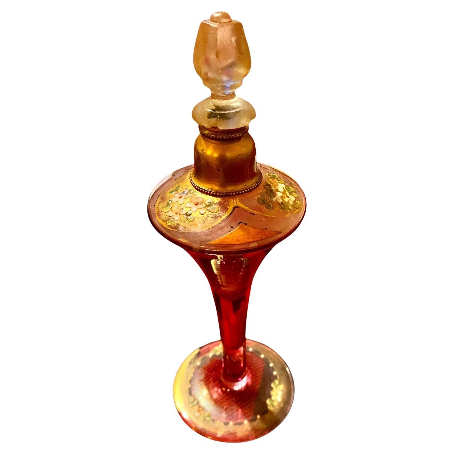 A circa 1920 Czechoslovakian red stained glass fluted perfume bottle, pedestal base with raised enameled floral and beaded decoration.