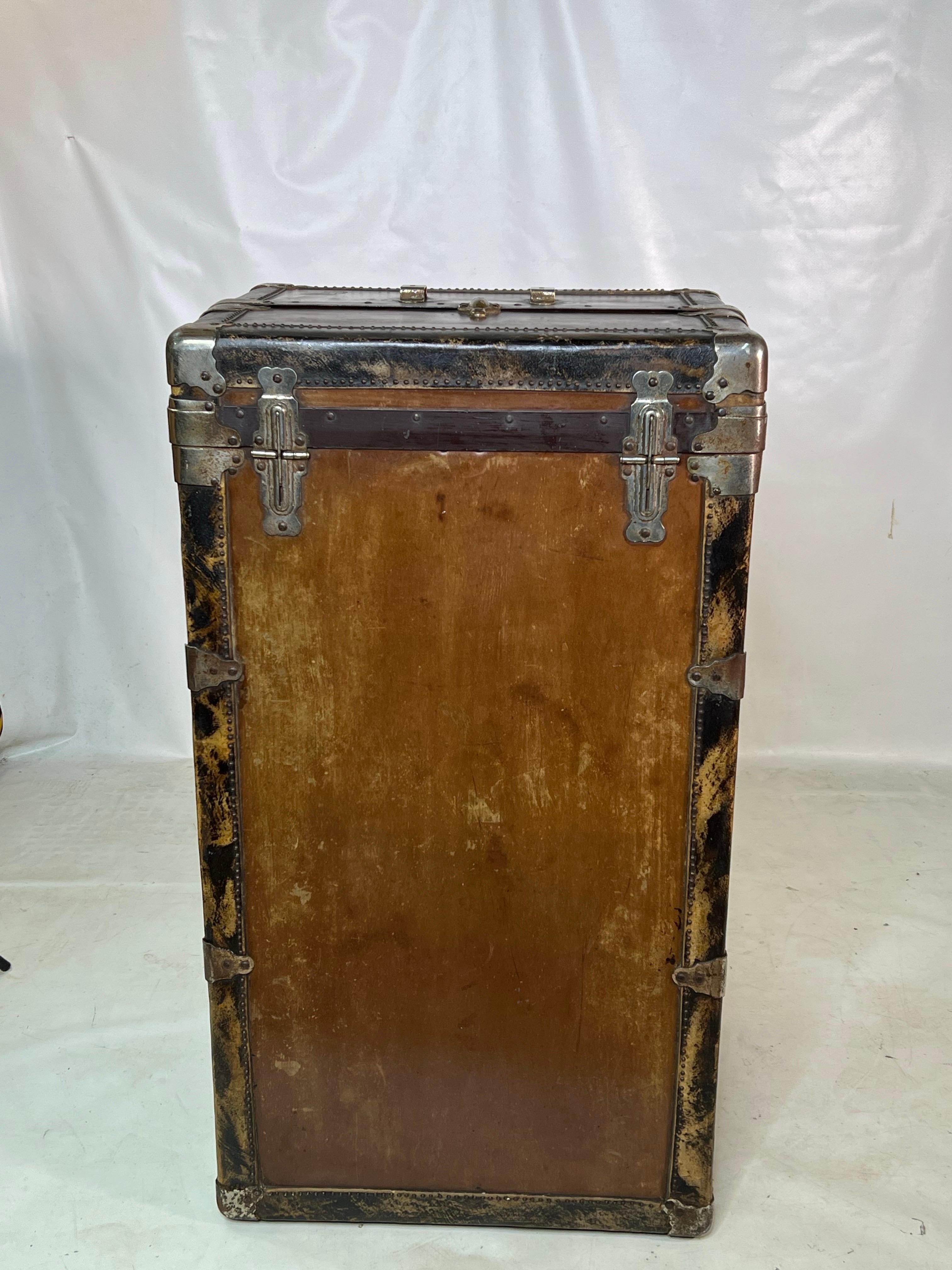 For sale is a stunning antique steamer trunk, complete with its original features. This trunk boasts exceptional craftsmanship and represents one of the higher-end models of its time. Inside, you'll find luxurious velvet lining, while the corners