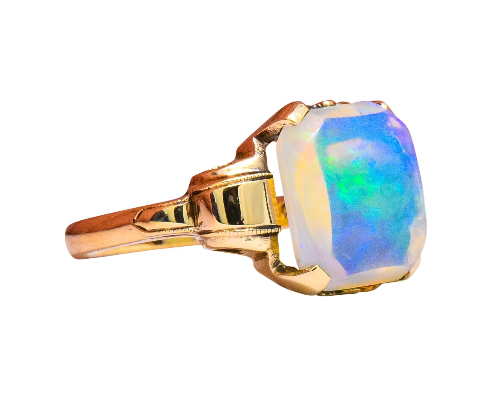 Centering a rectangular, cut-corner, buff top jelly opal

Translucent to transparent

Displaying very good play-of-color mostly in the green, violet and blue range 

Ring stamped R & S and 10K

Ring Size: 6 1/2 & Sizable

Top measures 12.2 mm and