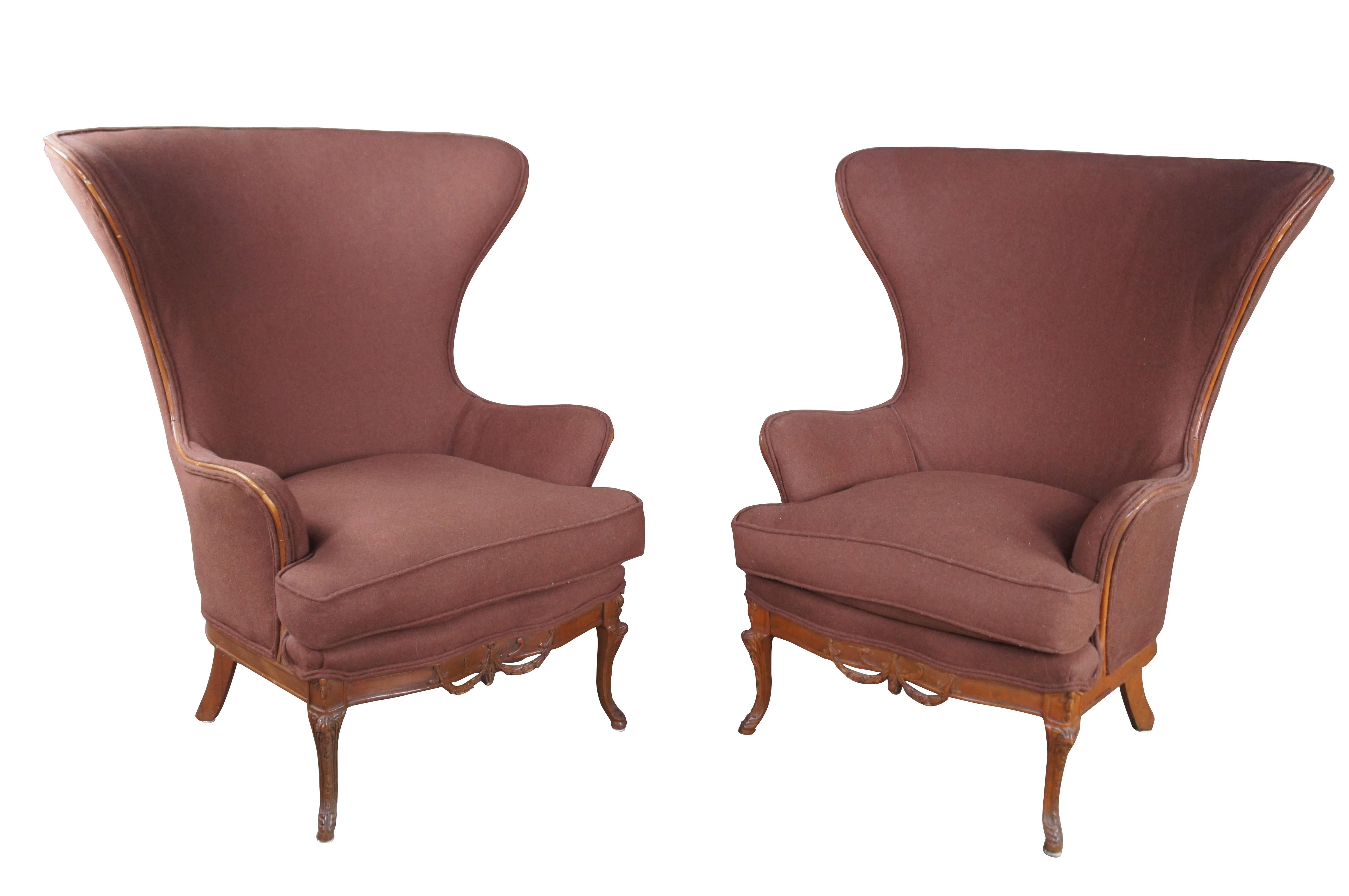 Pareja de sillas de biblioteca Johnson Chair Company, años 20.  Presenta un marco de caoba con un motivo neoclásico en forma de sable a lo largo del centro y patas de sable talladas.  Las sillas están tapizadas en mohair marrón claro con un