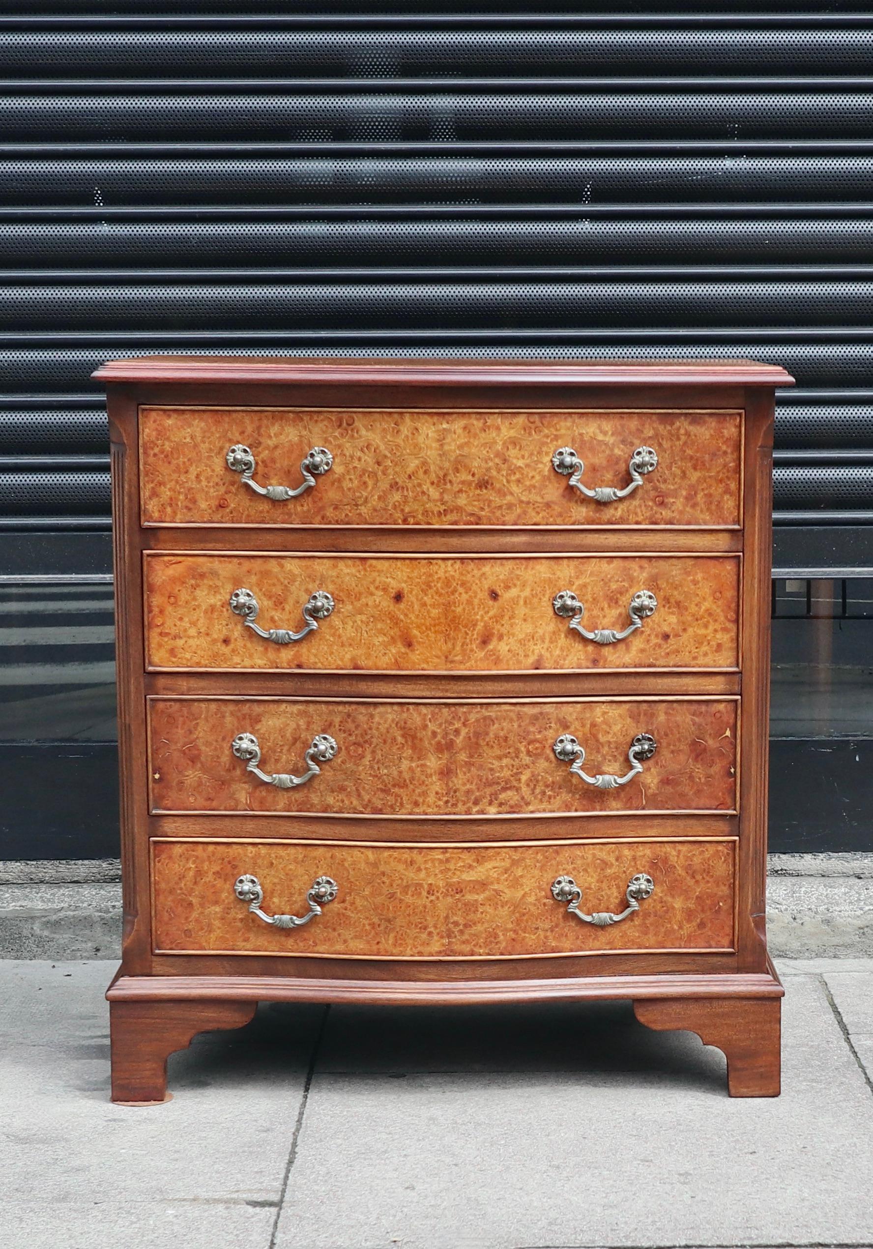 A stylish and beautiful English 1920s four drawer night stand/chest of drawers with a solid mahogany carcass, burr walnut fronts and metal handles.