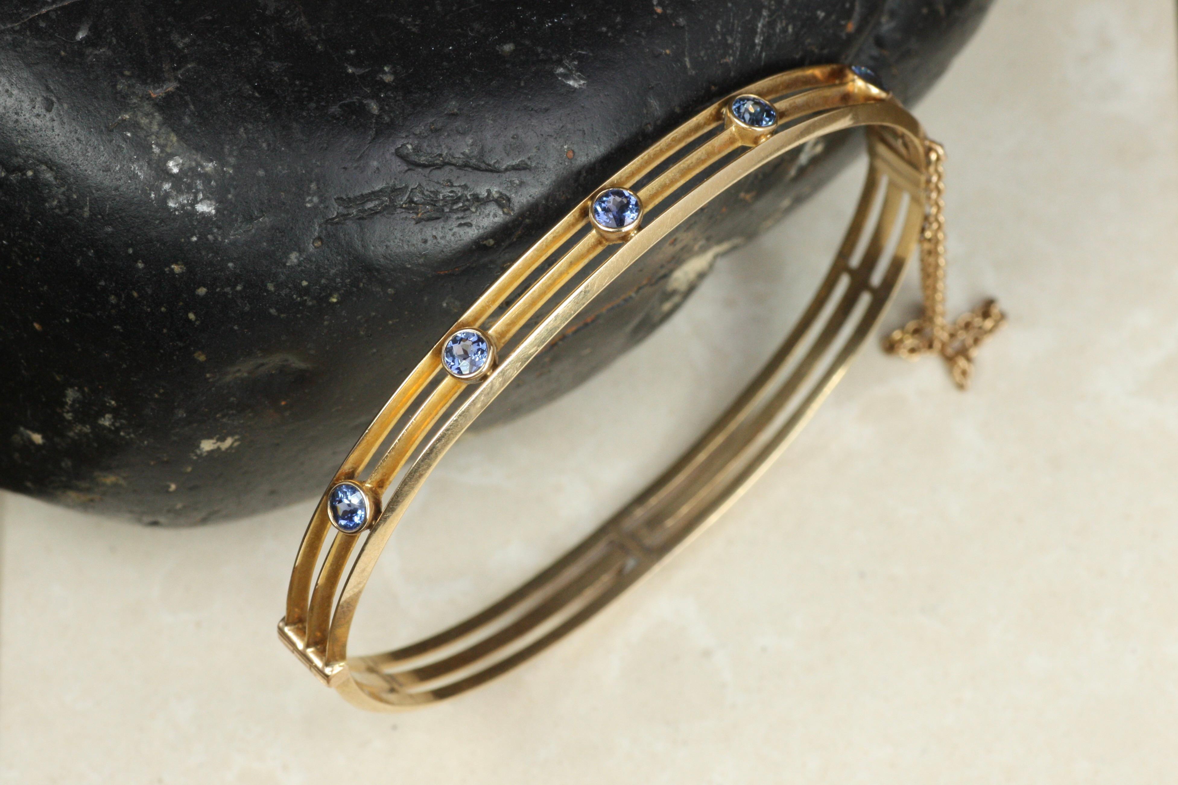 Antico bracciale ovale a cerniera in oro rosa 14K con cinque zaffiri naturali del Montana, circa 1910, dalla collezione di gioielli antichi di Bracken Jewellers a Santa Monica, California. Le tre file sono intervallate da fili e il bracciale è