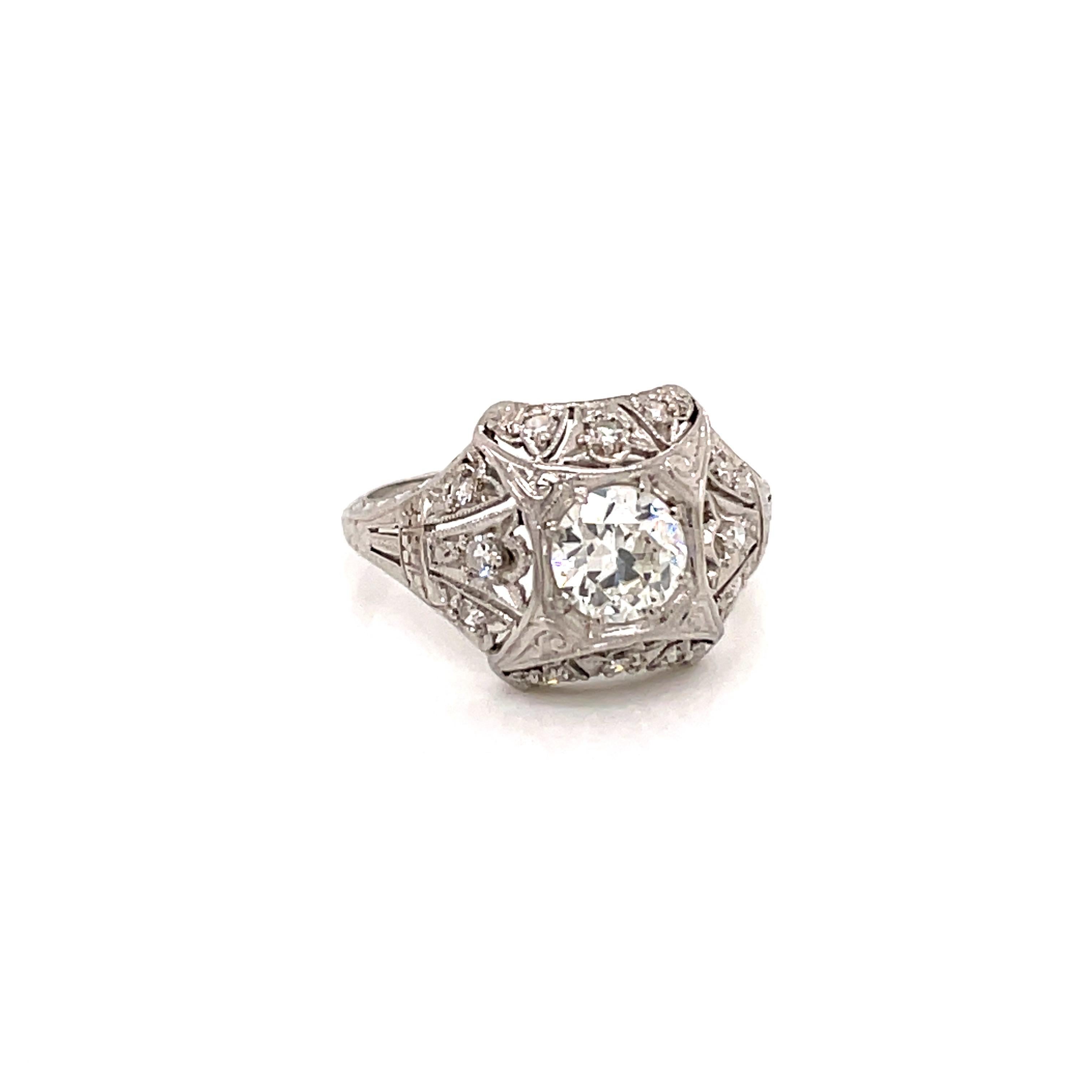 Antique 1920s Platinum Diamond Engagement Ring - The center old European Cut diamond weighs .74ct and is I color and VS2 clarity. The ornate filigree setting contains 12 single cut diamonds with an approximate weight of .18ct. The platinum setting
