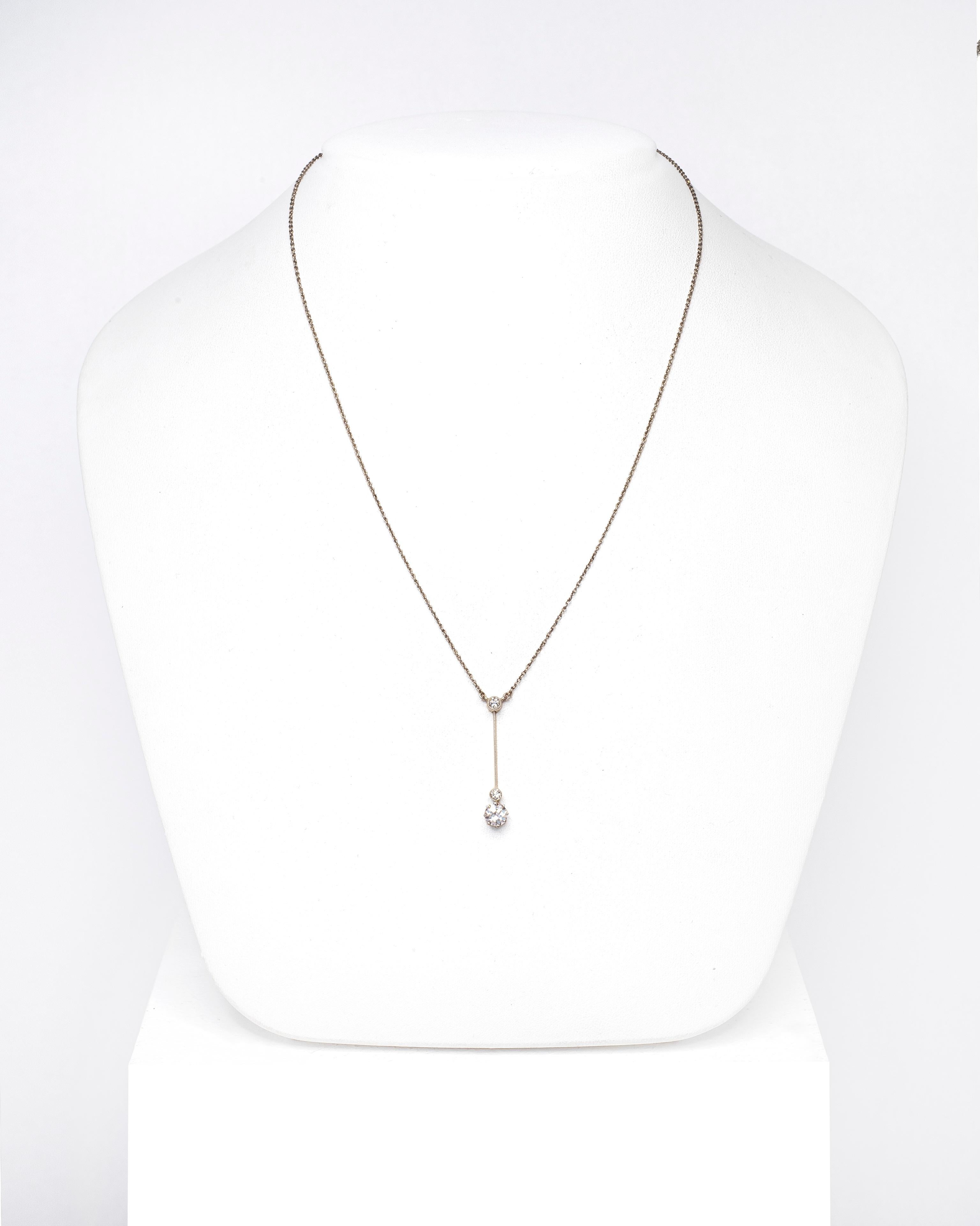 This necklace is nothing short of breathtaking. Three diamonds are set in a sleek and simplistic Art Deco design, crafted out of platinum on gold,  giving it a luxurious glow when it tilts and catches the light.

The largest diamond is fashioned in