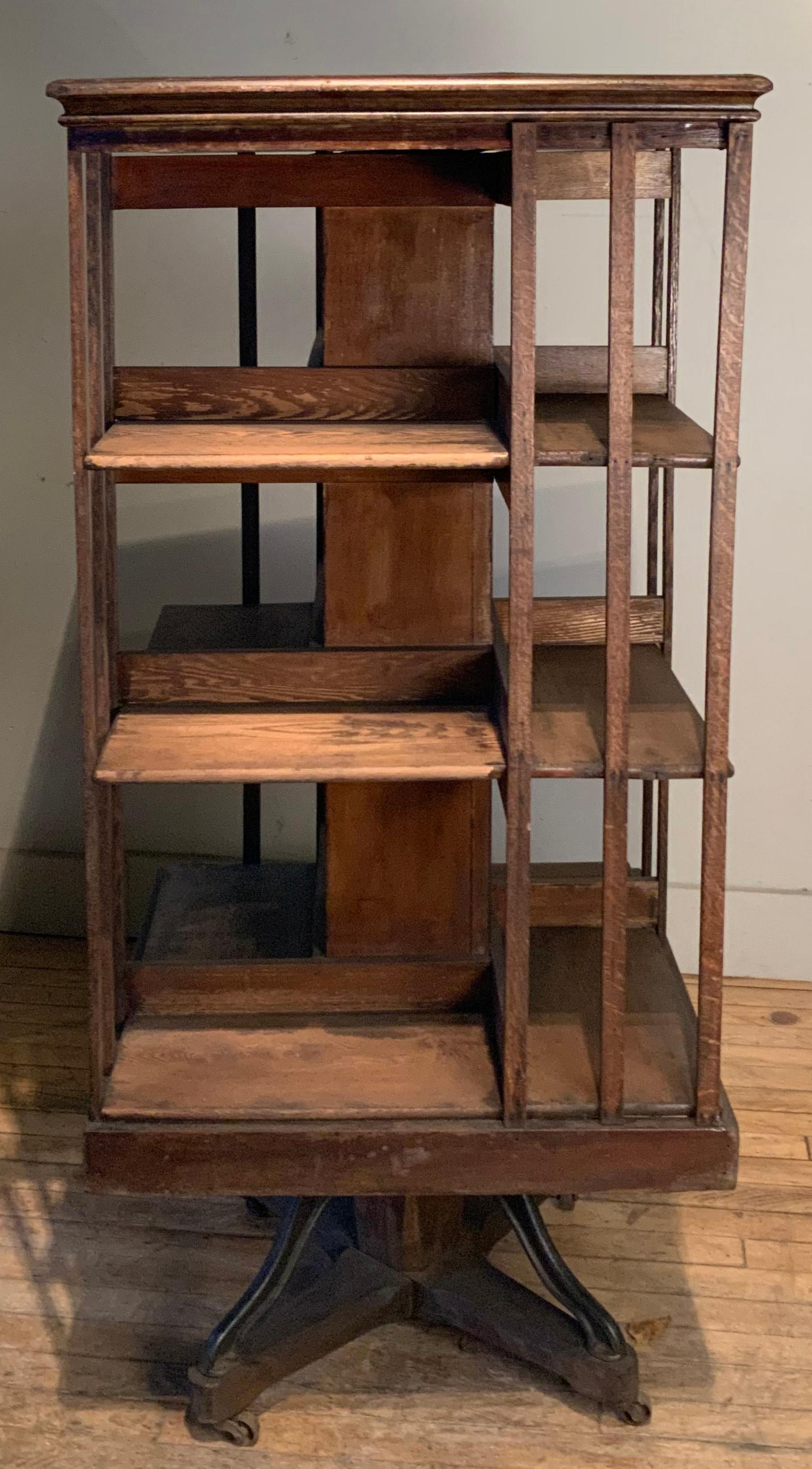 A wonderful and incredibly functional antique 1920's revolving bookcase. mounted on a base with cast iron mounts for extra support, it has four open sides with three shelves each. the whole piece turns easily on the center support. wonderful stylish