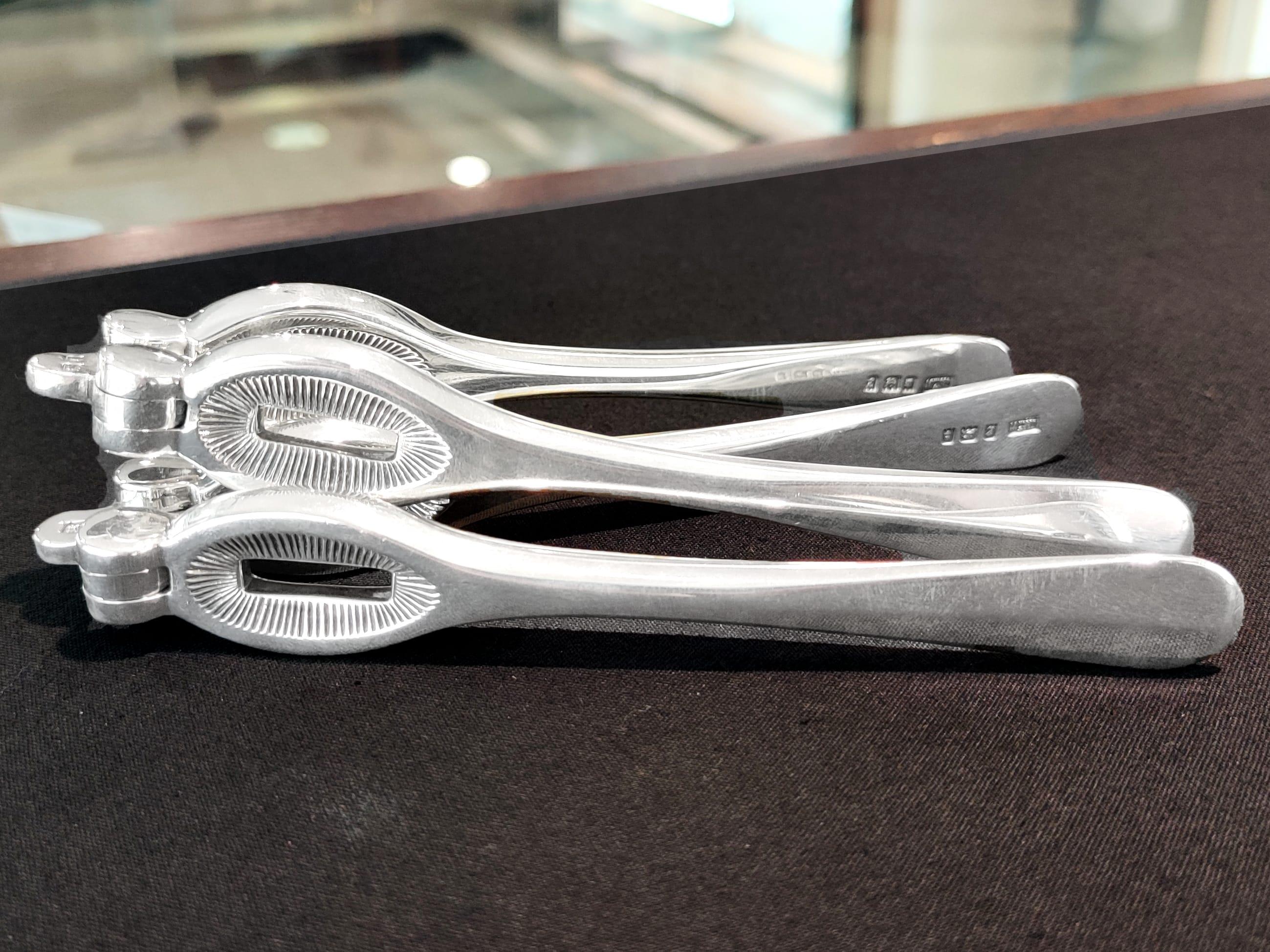 Ces exceptionnels casse-noix anciens en argent sterling de George V ont une forme arrondie simple.

Les poignées articulées et poinçonnées de cet impressionnant exemple de couverts anciens en argent sont simples et sans ornement.

Les mâchoires
