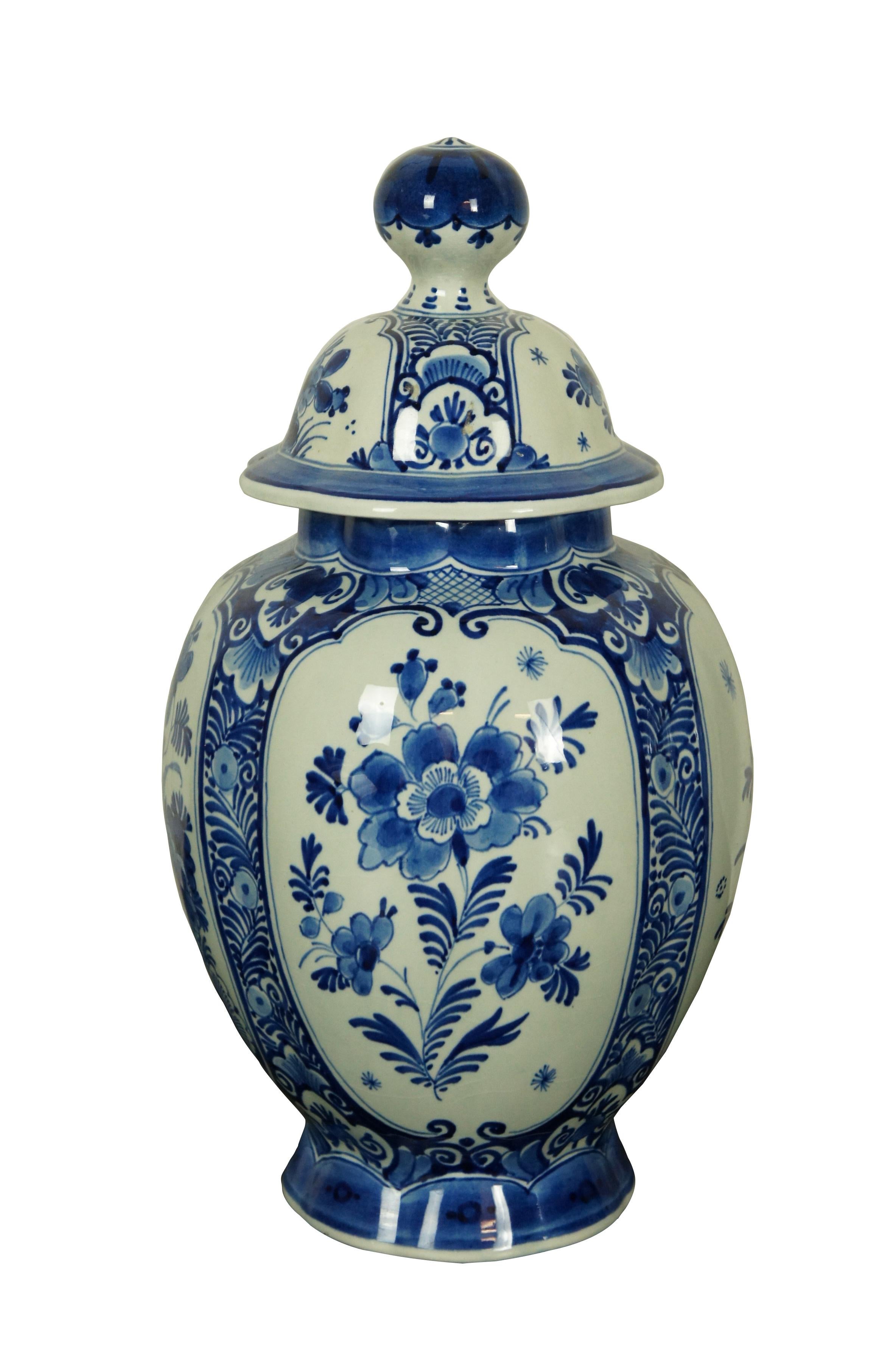 Pair of antique Royal Delft pottery blue and white porcelain mantel urns. Traditional temple urn / lobed pumpkin-like shape, scalloped rim and large round finials on lids. Hand decorated with various floral motifs in blue. Date Code: AR (1922).