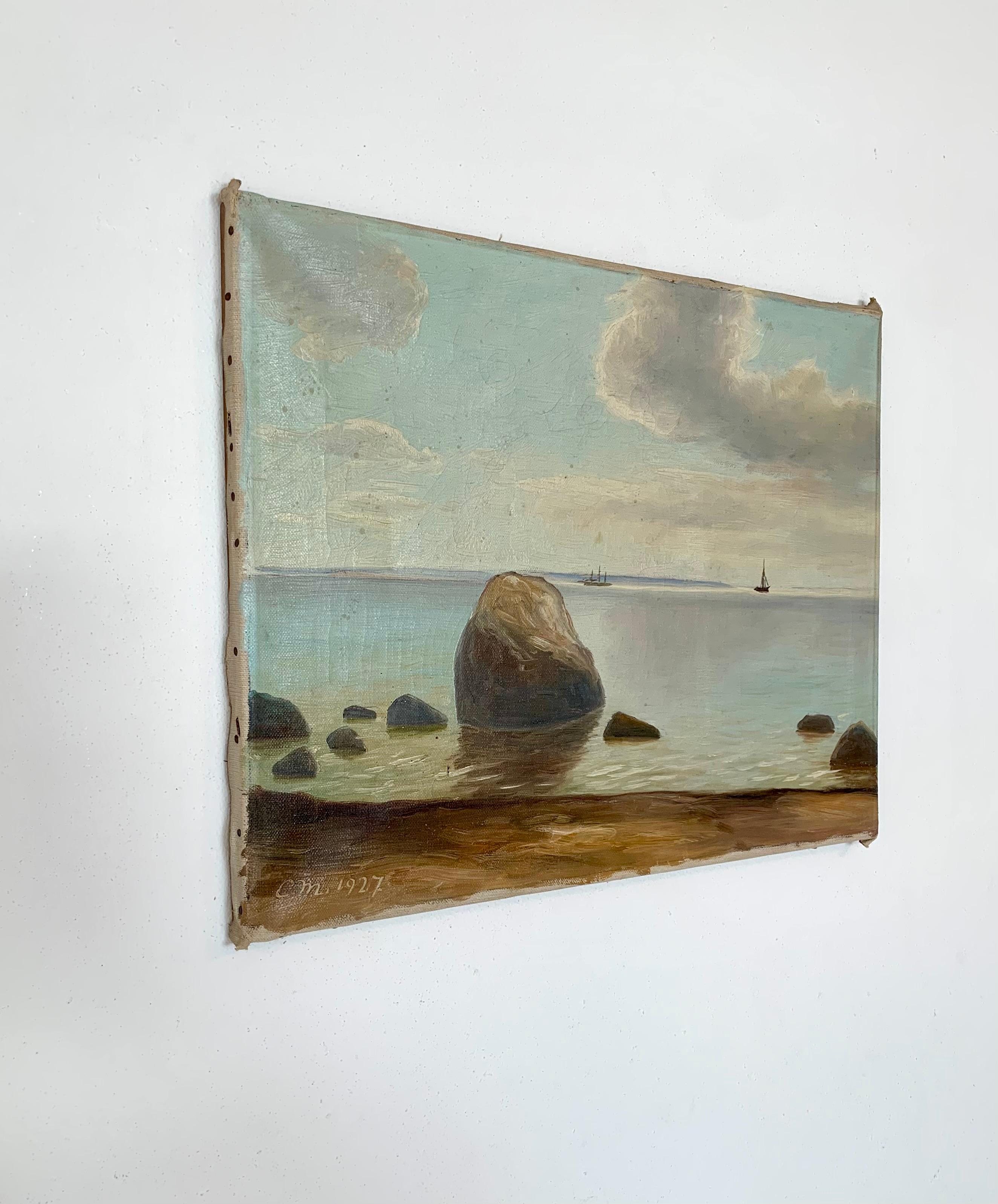 This is an antique maritime Scandinavian oil on canvas painting of a coastal landscape with rocks in the surf. A few sailing ships is seen in the horizon of the sea where the water meets a blue and clouded sky, slightly looming. 

This painting is