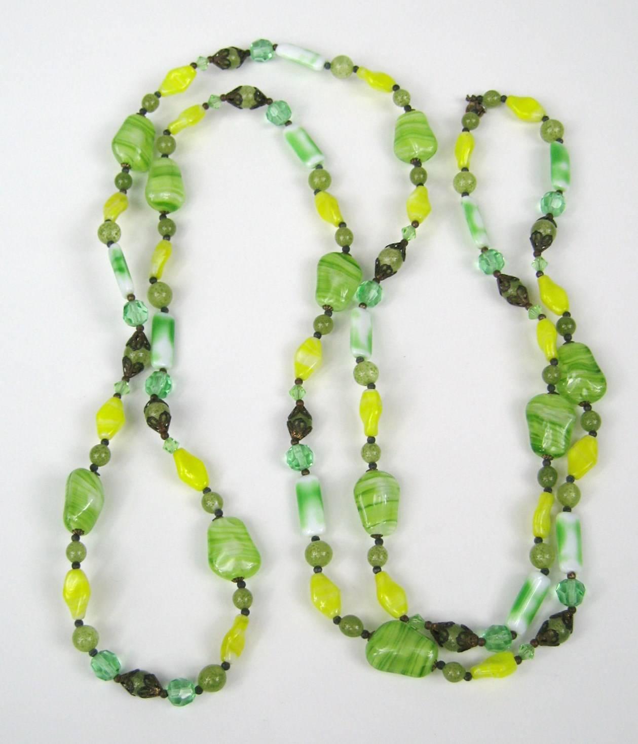 Stunning Greens and yellow beads. Long strand measuring 48 in end to end. Glass beads range in size from .78 in down to .25 in. Faceted as well, with metal end caps on them.This is out of a massive collection of Hopi, Zuni, Navajo, Southwestern,