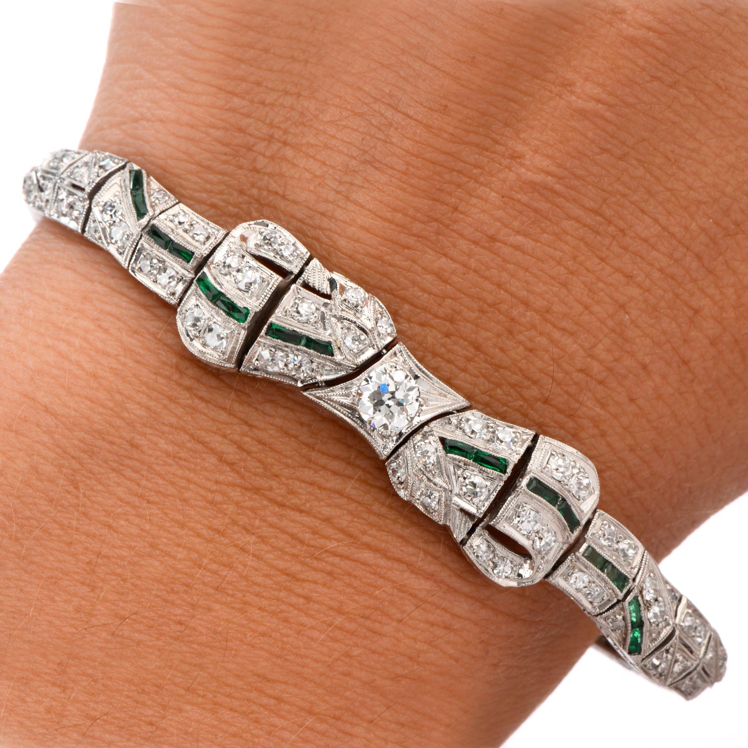 This Antique 1930's Ribbon and Bow inspired Diamond and Emerald Bracelet was crafted in luxurous Platinum. 
The bracelet drips in Diamonds from one end of the Ribbon to the other featuring an Emerald thread through the center.  This can be both the