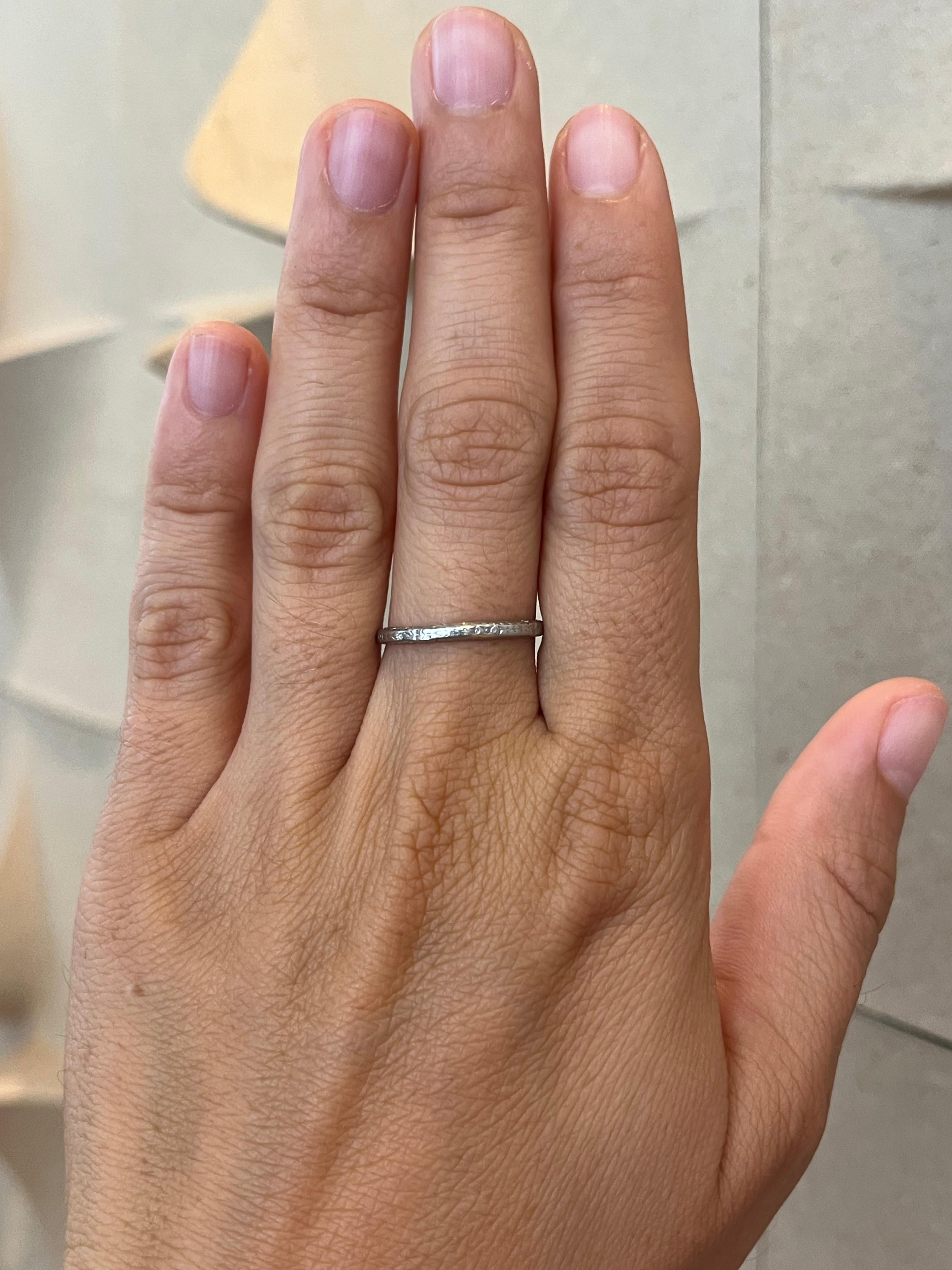 From the Bracken Jewelers antique fine jewelry collection in Santa Monica, California. A fine antique 1930s platinum wedding band featuring a hand-engraved wheat and floral pattern that wraps all of the way around the ring and carries onto the