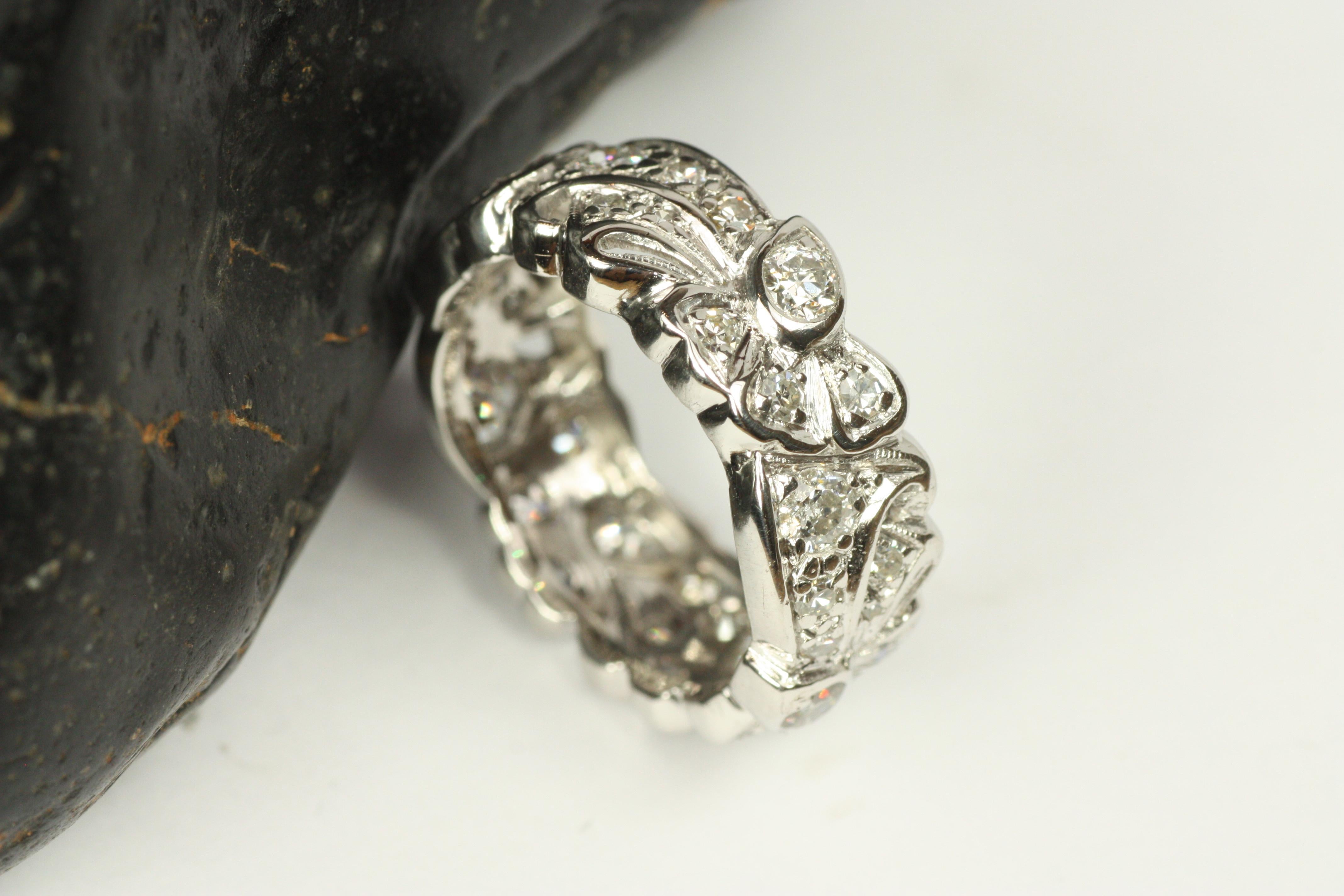 Antigua alianza de diamantes, hacia 1935, de la época moderne. Este brillante anillo ancho de 8 mm está salpicado de 34 diamantes naturales redondos que suman un total de 1,33 ct, engastados en un elaborado diseño de lazo y cinta. De ellos, los 6
