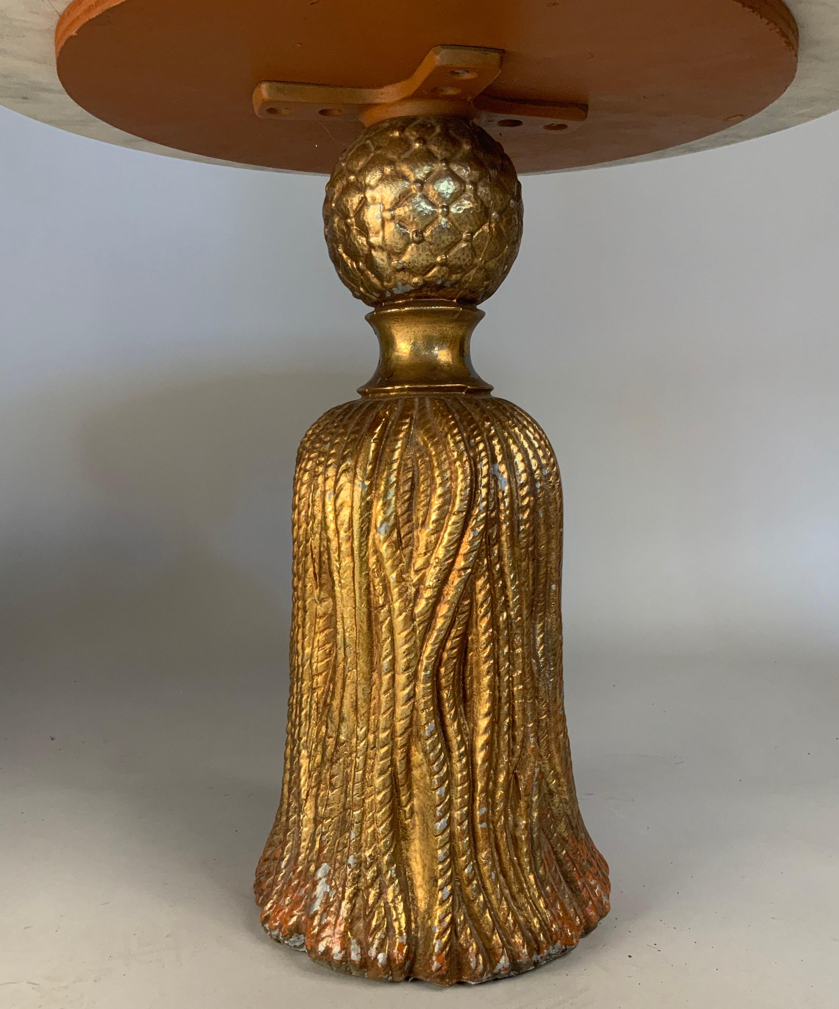 a very charming 1940's italian cocktail table made with a base in the form of a large tassel in cast metal, with a gilt finish, which is worn and chipped away in some spots, and an italian marble top that rests upon the table. perfect size and scale