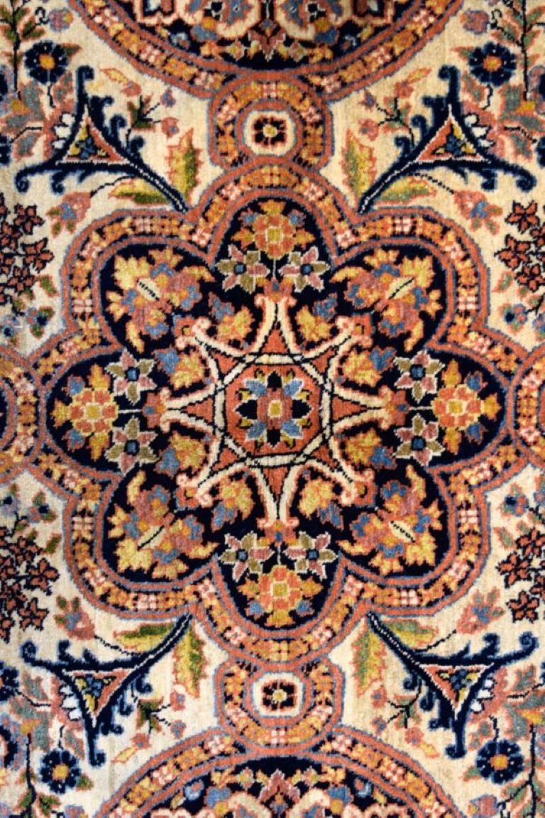 Approximately 5' x 7', this antique wool carpet from the Semnan province, resplendent with tones of cream, black, blue, and pink, dates to the 1940s. Vegetable dyes provide the piece with its well-balance and vibrant tones. Measuring exactly 4’7” x